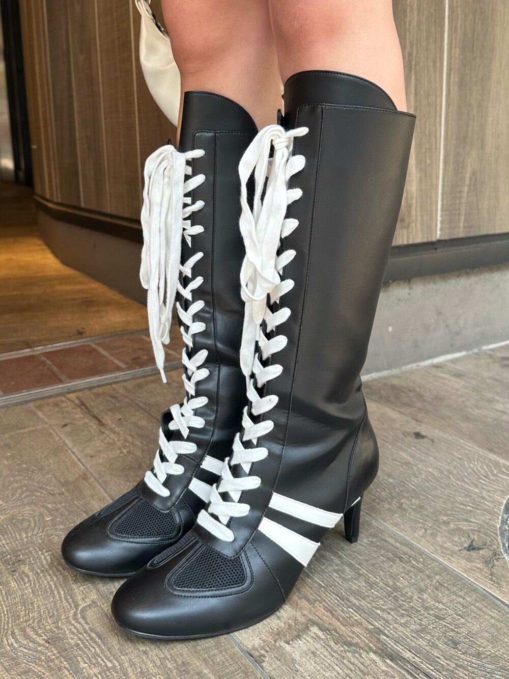 ホワイト系のショルダーバッグ、ブラック系のブーツ、グレー系のスウェットを着用したレディースの春コーディネートの9枚目の写真