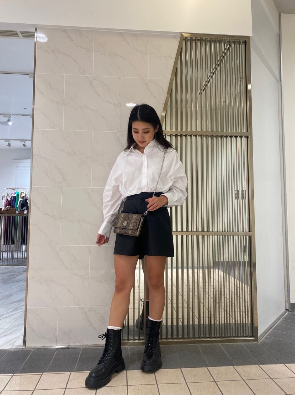 ブラック系のその他パンツ、ブラック系のブーツ、ホワイト系のシャツ/ブラウスを着用したレディースの夏コーディネートの2枚目の写真