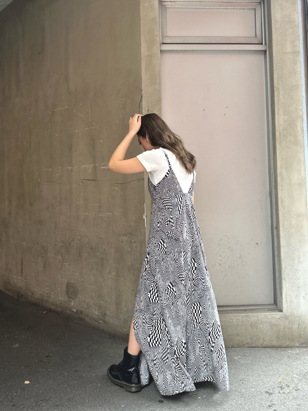 ブラック系のワンピース、ホワイト系のTシャツ/カットソー、ブラック系のハンドバッグを着用したレディースの春コーディネートの2枚目の写真