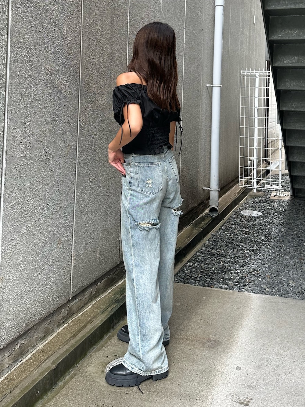 ブルー系のデニムパンツ、ブラック系のシャツ/ブラウス、ブラック系のブーツを着用したレディースの夏コーディネートの2枚目の写真