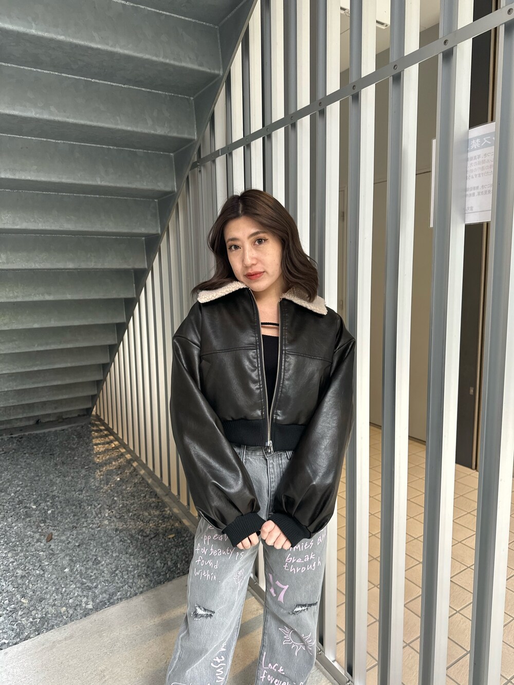 ブラック系のデニムパンツ、ブラック系のブルゾン、ブラック系のTシャツ/カットソーを着用したレディースの冬コーディネートの5枚目の写真