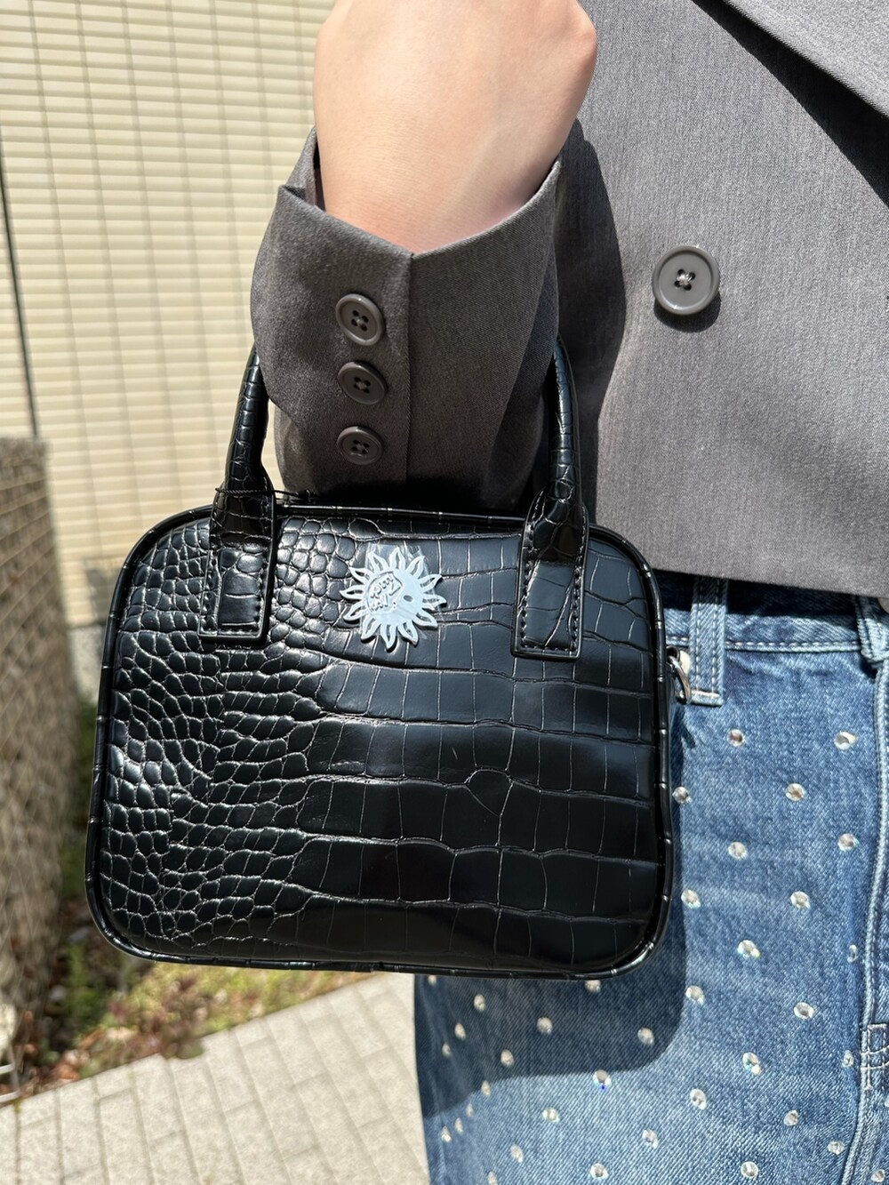 ブラック系のブーツ、グレー系のテーラードジャケット、ホワイト系のシャツ/ブラウスを着用したレディースの春コーディネートの7枚目の写真