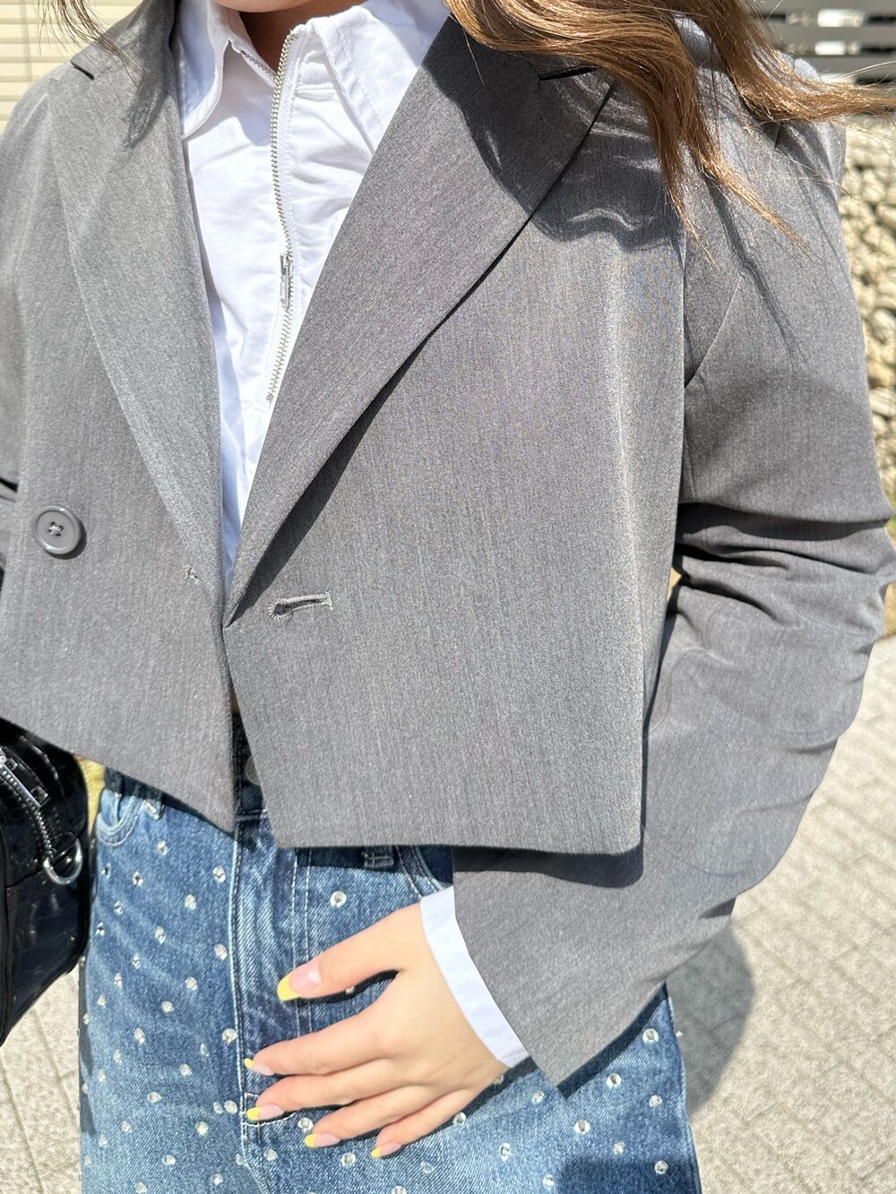 ブラック系のブーツ、グレー系のテーラードジャケット、ホワイト系のシャツ/ブラウスを着用したレディースの春コーディネートの5枚目の写真