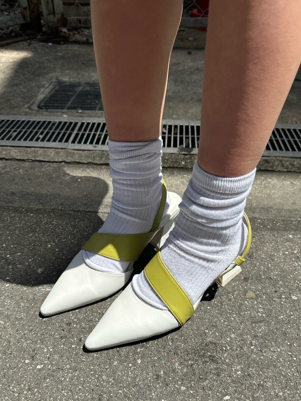 ホワイト系のTシャツ/カットソー、ホワイト系のサンダル、ホワイト系のハンドバッグを着用したレディースの春コーディネートの7枚目の写真