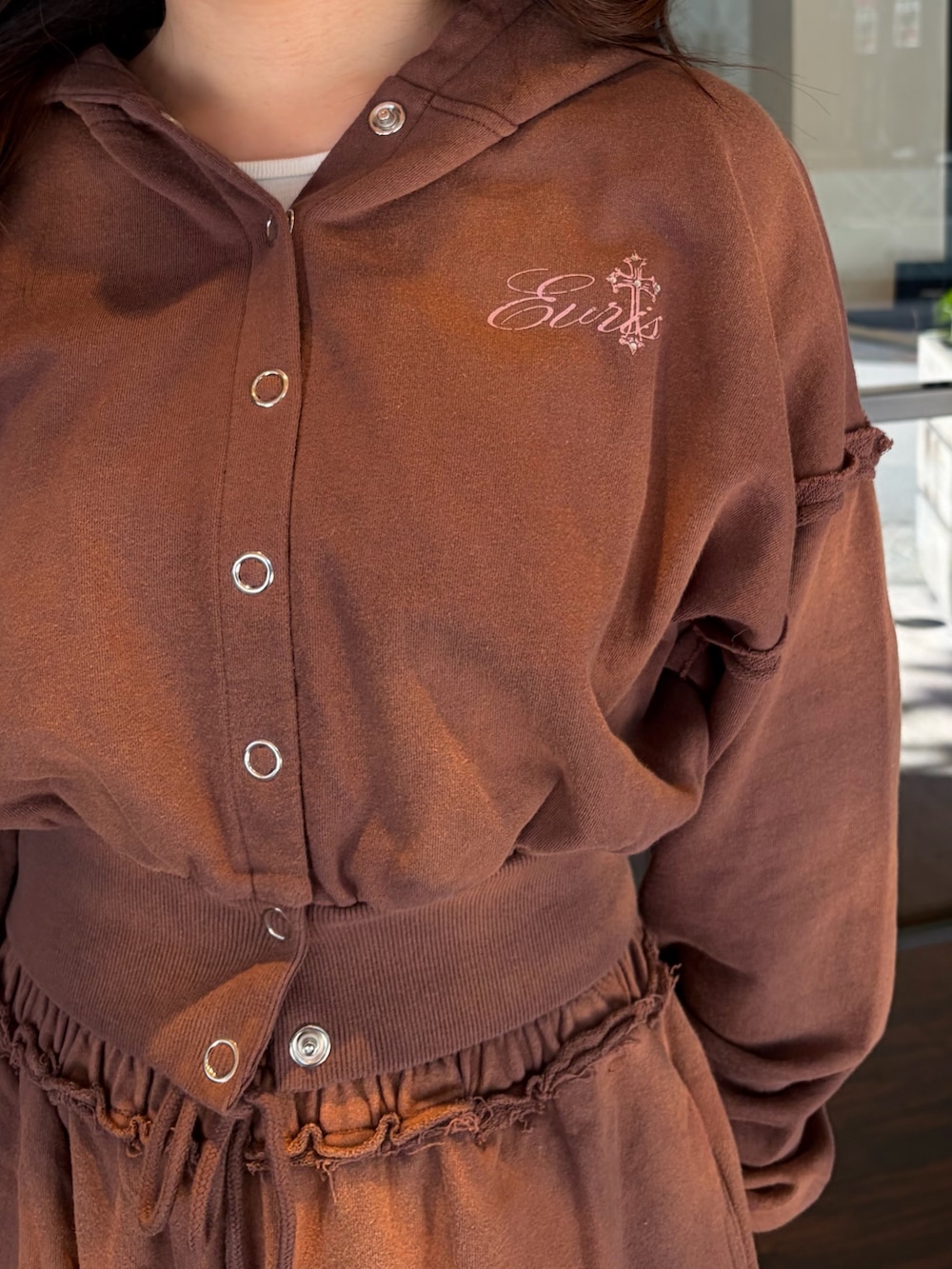 ブラウン系のスウェットパンツ、ブラウン系のパーカー、ブラック系のブーツを着用したレディースの春コーディネートの6枚目の写真