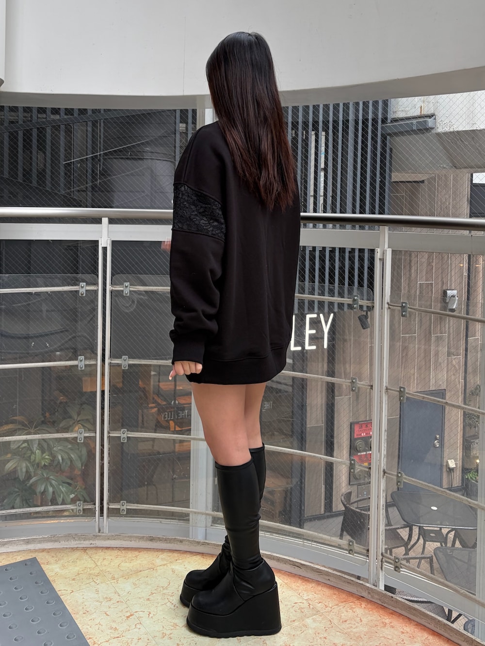 ブラック系のスウェット、ブラック系のブーツを着用したレディースの冬コーディネートの2枚目の写真