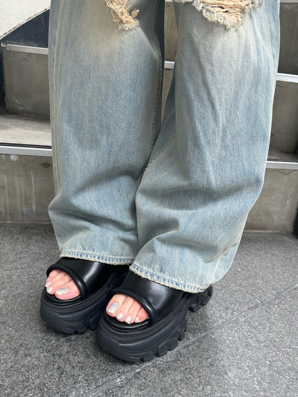 ホワイト系のニット/セーター、ブルー系のデニムパンツ、ブラック系のサンダルを着用したレディースの夏コーディネートの9枚目の写真