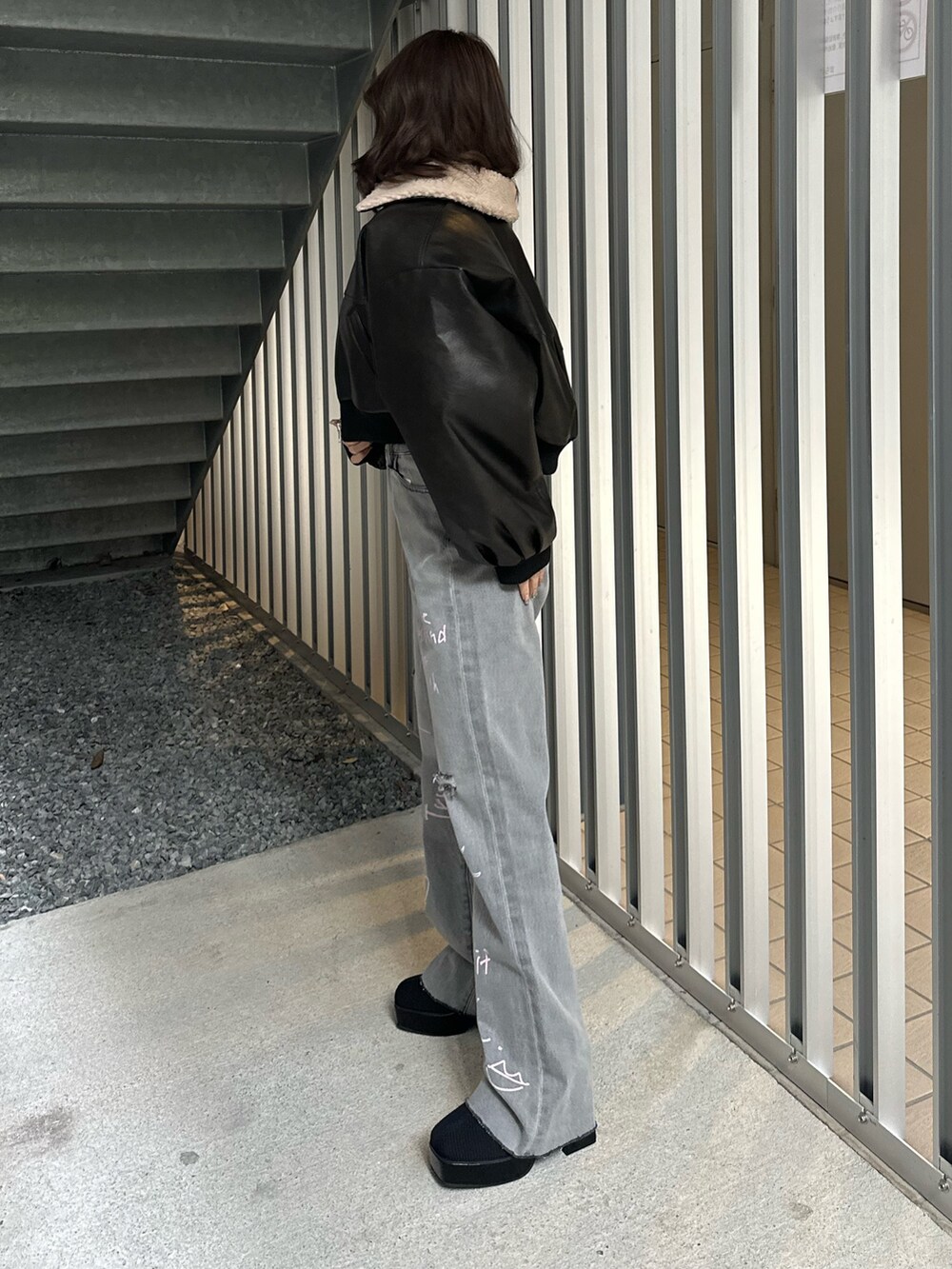 ブラック系のデニムパンツ、ブラック系のブルゾン、ブラック系のTシャツ/カットソーを着用したレディースの冬コーディネートの3枚目の写真