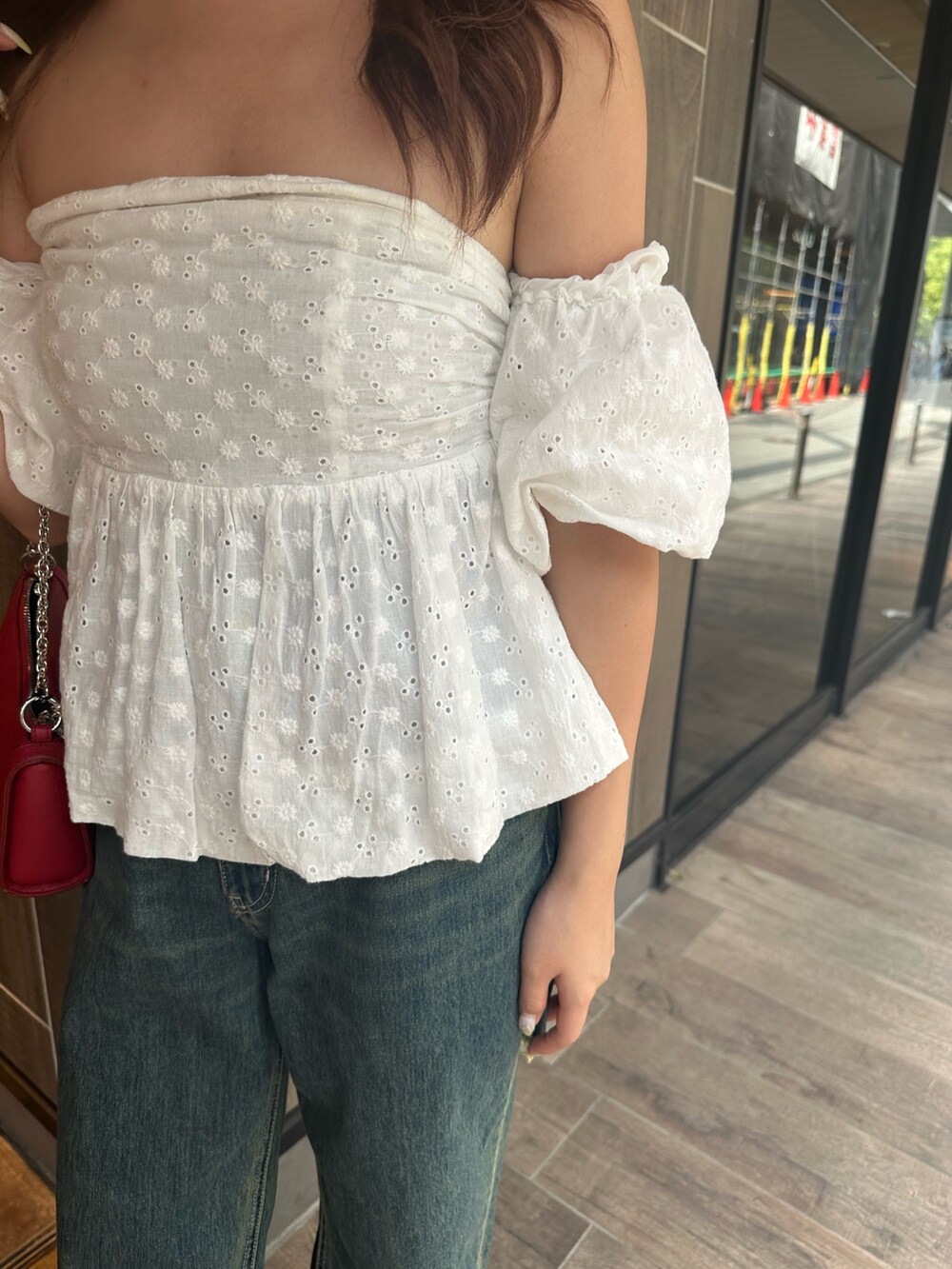 ブルー系のデニムパンツ、ホワイト系のシャツ/ブラウス、レッド系のショルダーバッグを着用したレディースの夏コーディネートの7枚目の写真