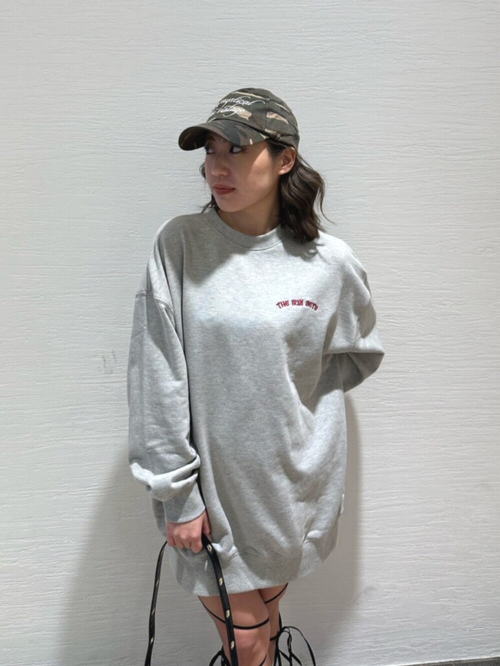 ブラック系のショルダーバッグ、ブラック系のブーツ、グレー系のスウェットを着用したレディースの冬コーディネートの5枚目の写真