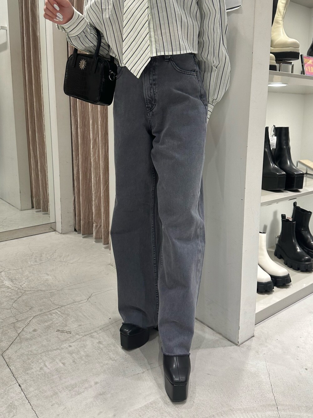 グレー系のデニムパンツ、ホワイト系のシャツ/ブラウス、ブラック系のショルダーバッグを着用したレディースの冬コーディネートの5枚目の写真