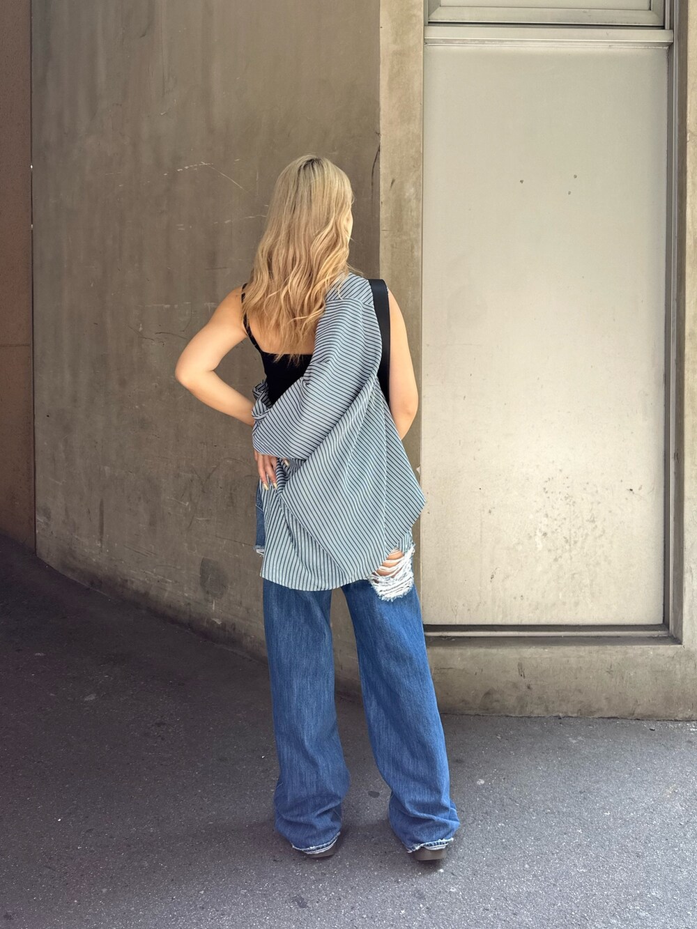 ブルー系のデニムパンツ、ブラック系のショルダーバッグ、グリーン系のシャツ/ブラウスを着用したレディースの夏コーディネートの3枚目の写真