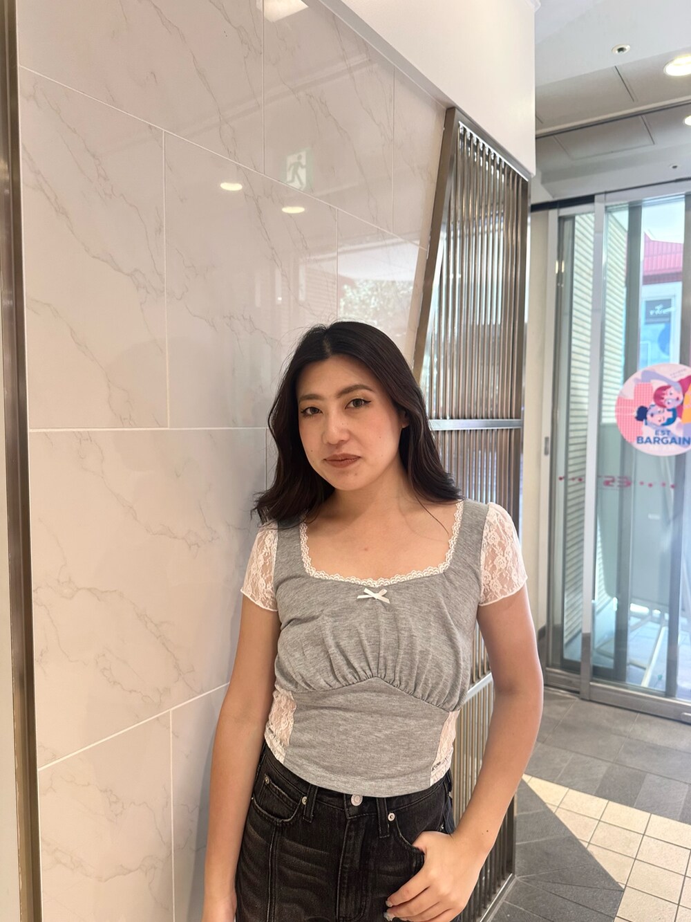 ブラック系のデニムパンツ、ブラック系のサンダル、グレー系のTシャツ/カットソーを着用したレディースの夏コーディネートの4枚目の写真