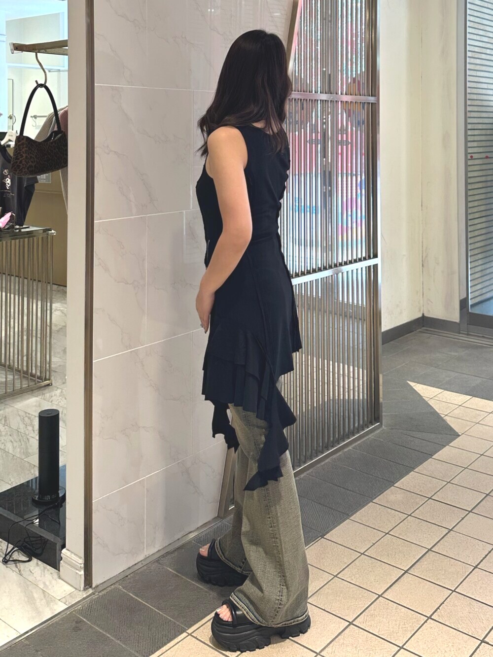 ブラック系のサンダル、ブルー系のデニムパンツ、ブラック系のワンピースを着用したレディースの夏コーディネートの2枚目の写真