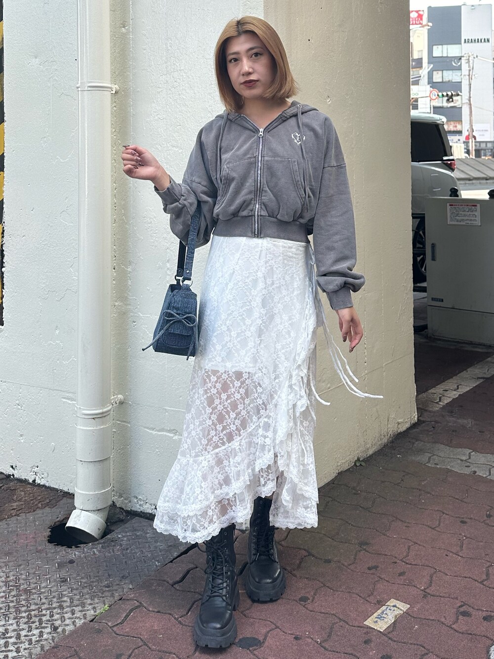 ホワイト系のスカート、グレー系のスウェット、ブラック系のブーツを着用したレディースの秋コーディネートの2枚目の写真
