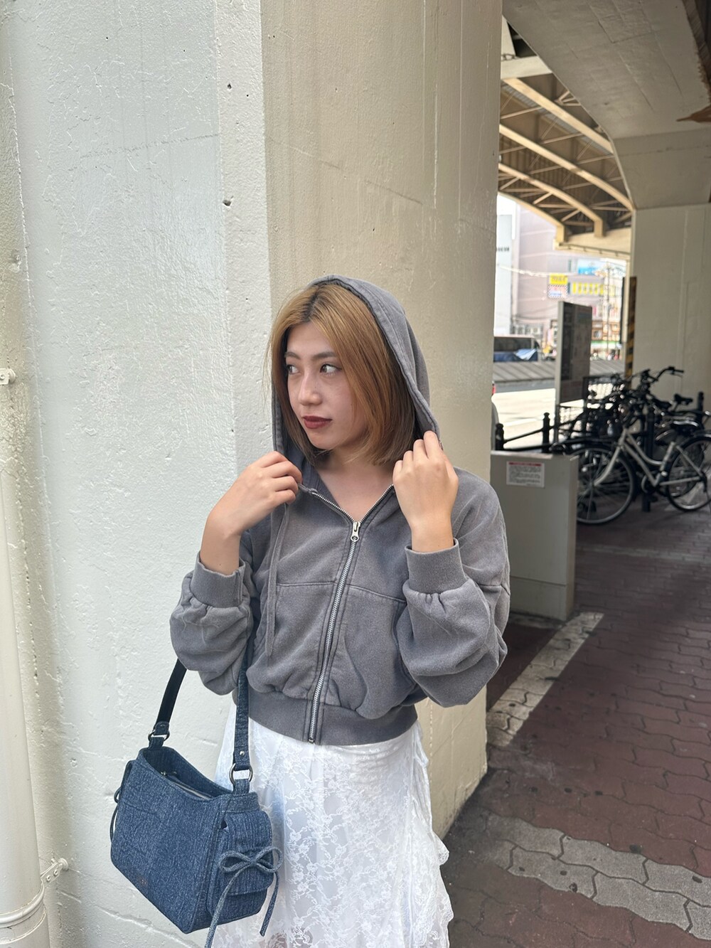 ホワイト系のスカート、グレー系のスウェット、ブラック系のブーツを着用したレディースの秋コーディネートの5枚目の写真