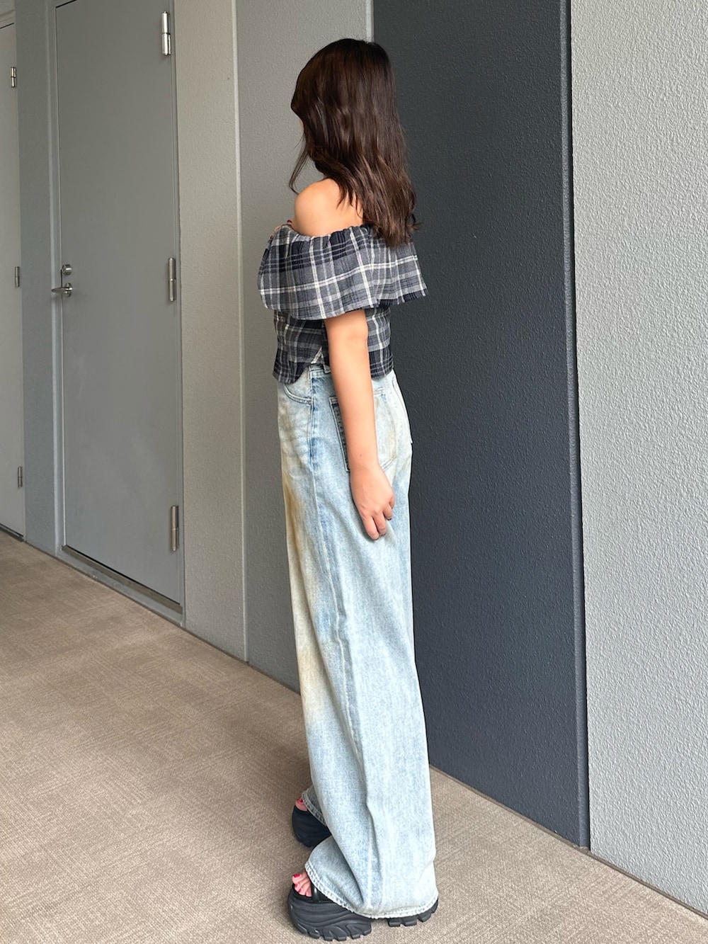 ブルー系のデニムパンツ、ブラック系のシャツ/ブラウス、ブラック系のサンダルを着用したレディースの夏コーディネートの2枚目の写真