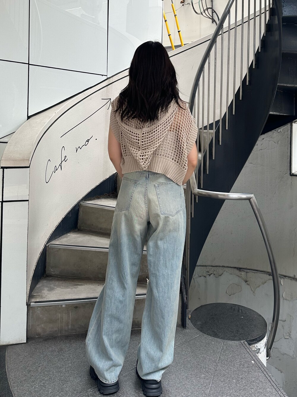 ホワイト系のニット/セーター、ブルー系のデニムパンツ、ブラック系のサンダルを着用したレディースの夏コーディネートの4枚目の写真