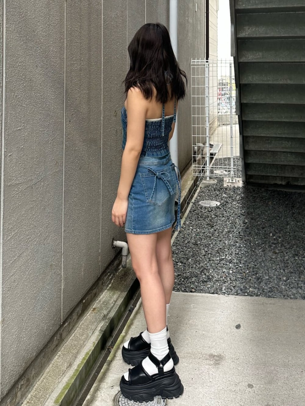 ブラック系のサンダル、ブルー系のキャミソール、ブルー系のデニムスカートを着用したレディースの夏コーディネートの2枚目の写真