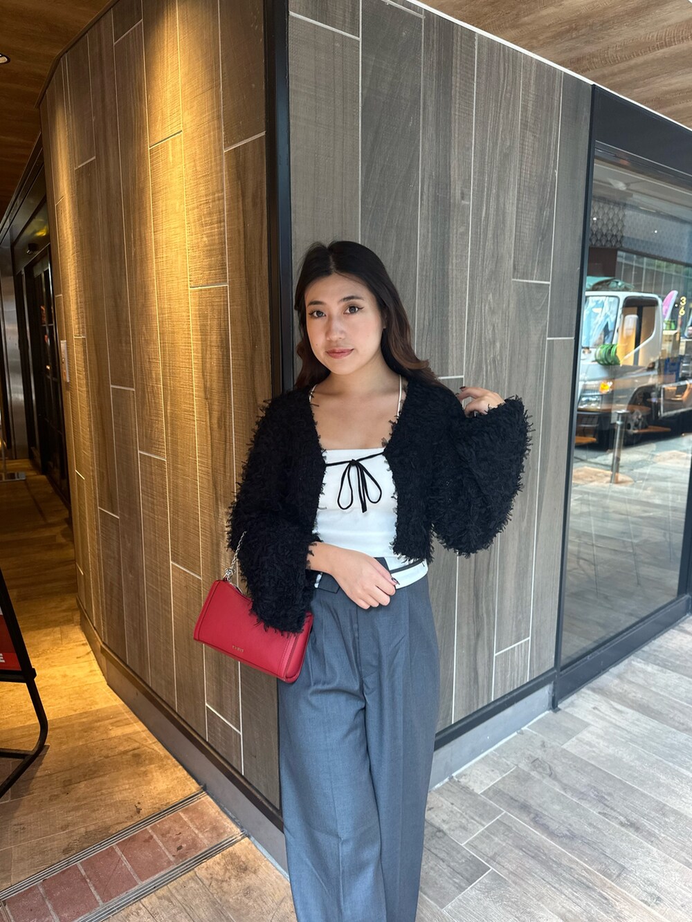 ブラック系のニット/セーター、グレー系のその他パンツ、レッド系のショルダーバッグを着用したレディースの秋コーディネートの5枚目の写真