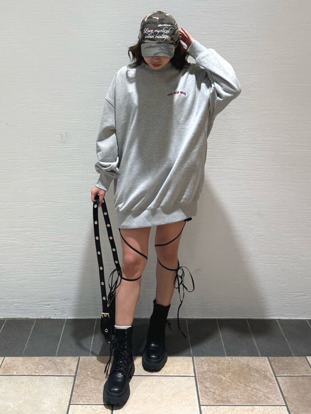 ブラック系のショルダーバッグ、ブラック系のブーツ、グレー系のスウェットを着用したレディースの冬コーディネートの2枚目の写真