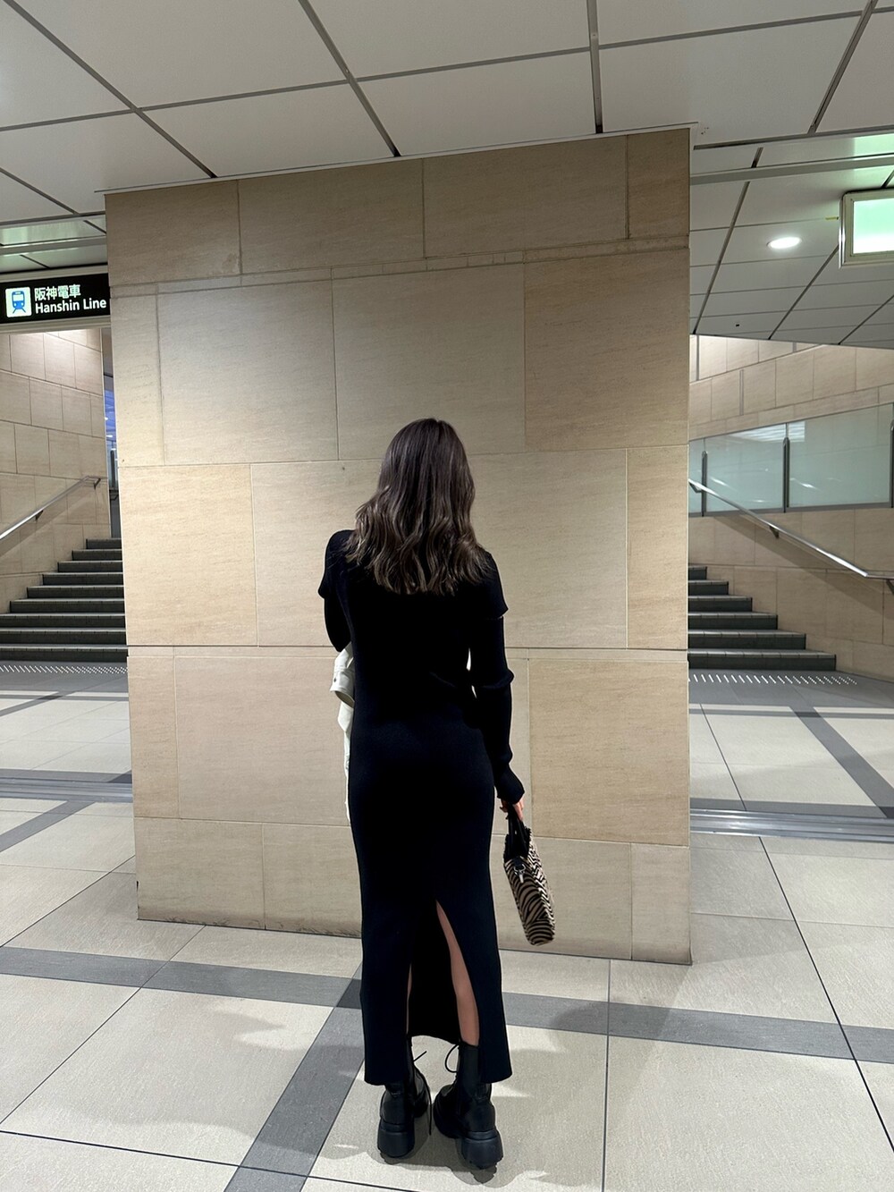 ブラック系のワンピース、ホワイト系のライダースジャケット、その他のショルダーバッグを着用したレディースの冬コーディネートの4枚目の写真