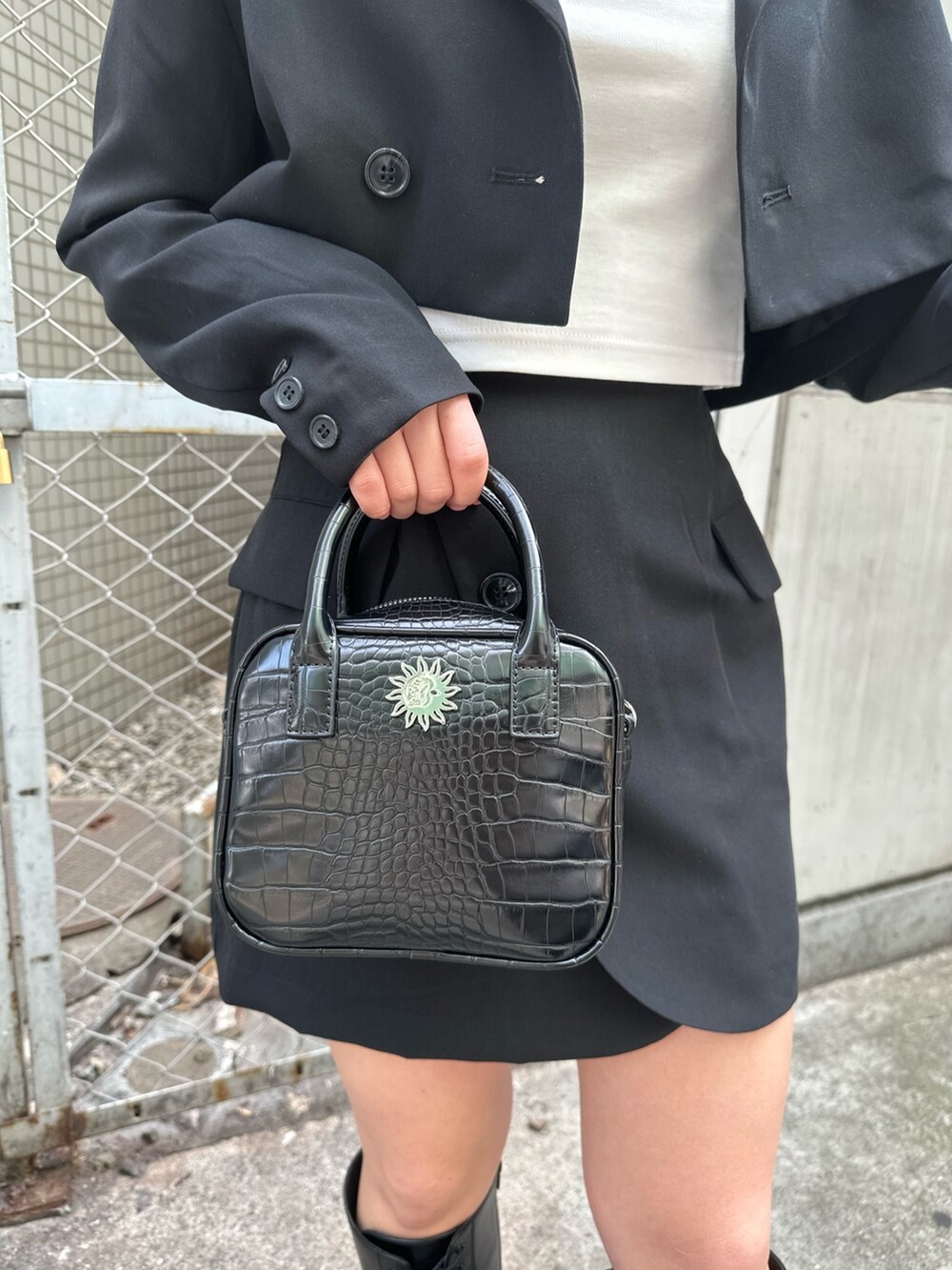 ホワイト系のTシャツ/カットソー、ブラック系のテーラードジャケット、ブラック系のスカートを着用したレディースの春コーディネートの7枚目の写真