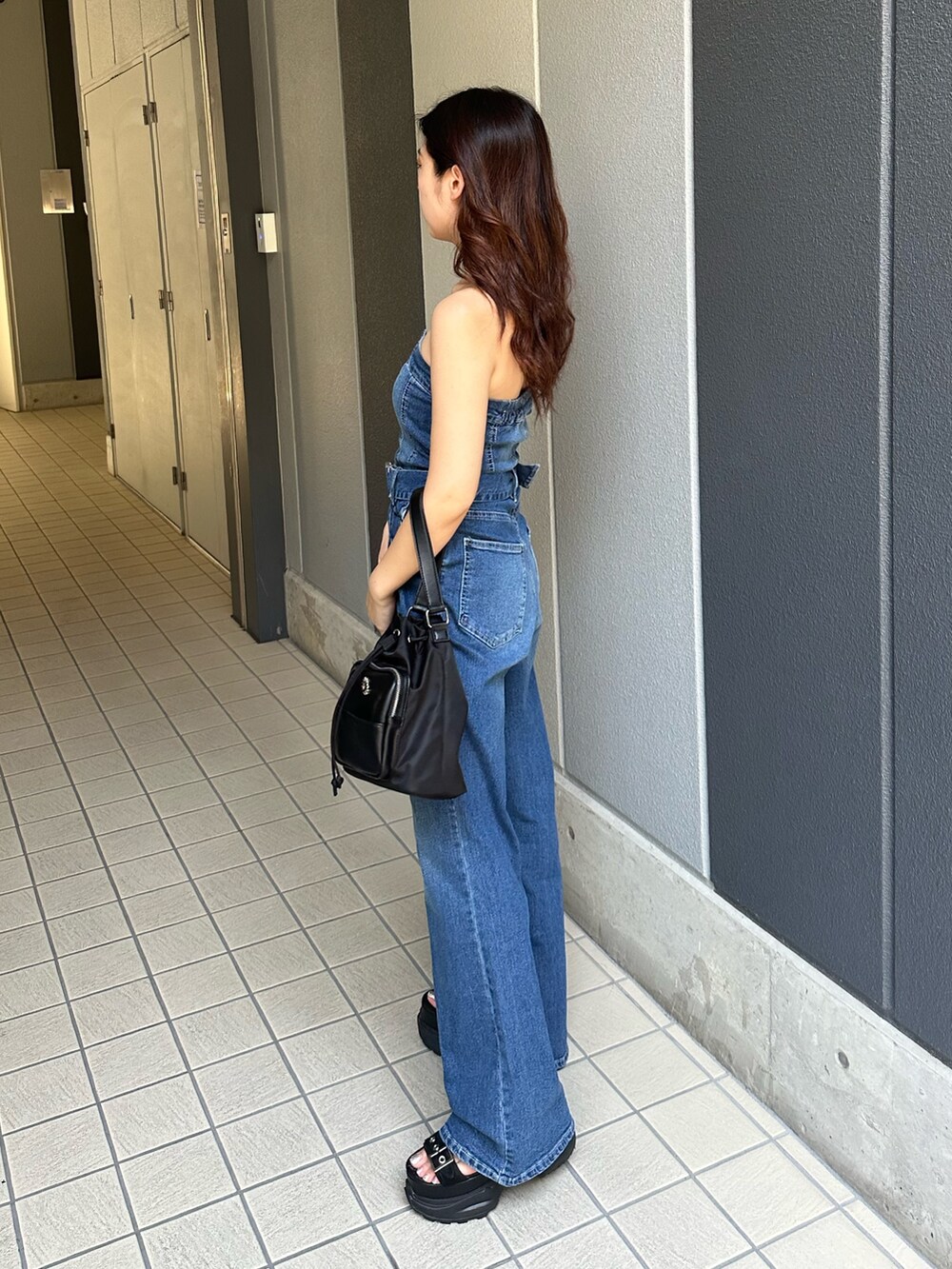 ブルー系のつなぎ/オールインワン、ブラック系のサンダル、ブラック系のショルダーバッグを着用したレディースの夏コーディネートの3枚目の写真