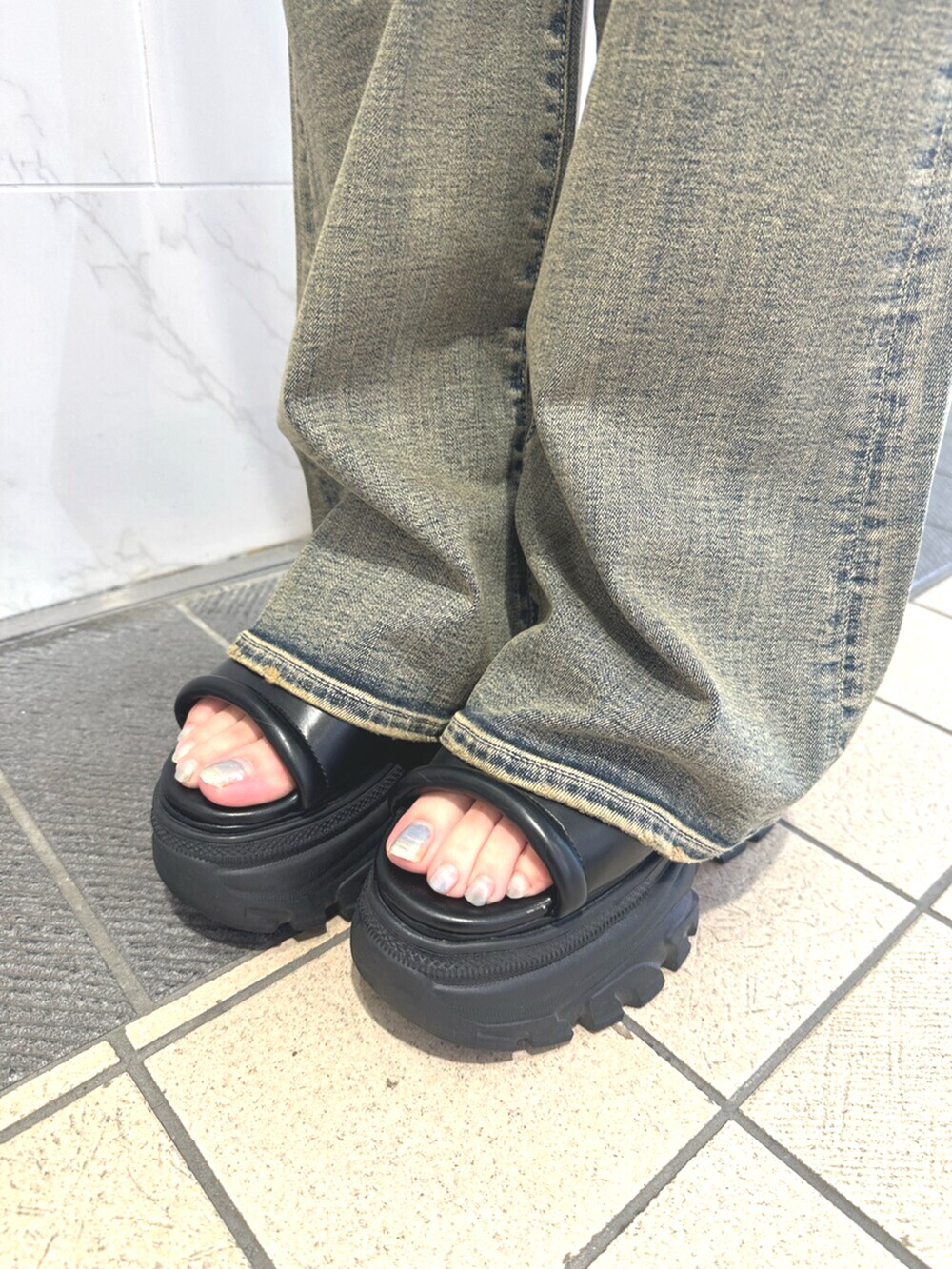 ブラック系のサンダル、ブルー系のデニムパンツ、ブラック系のワンピースを着用したレディースの夏コーディネートの7枚目の写真