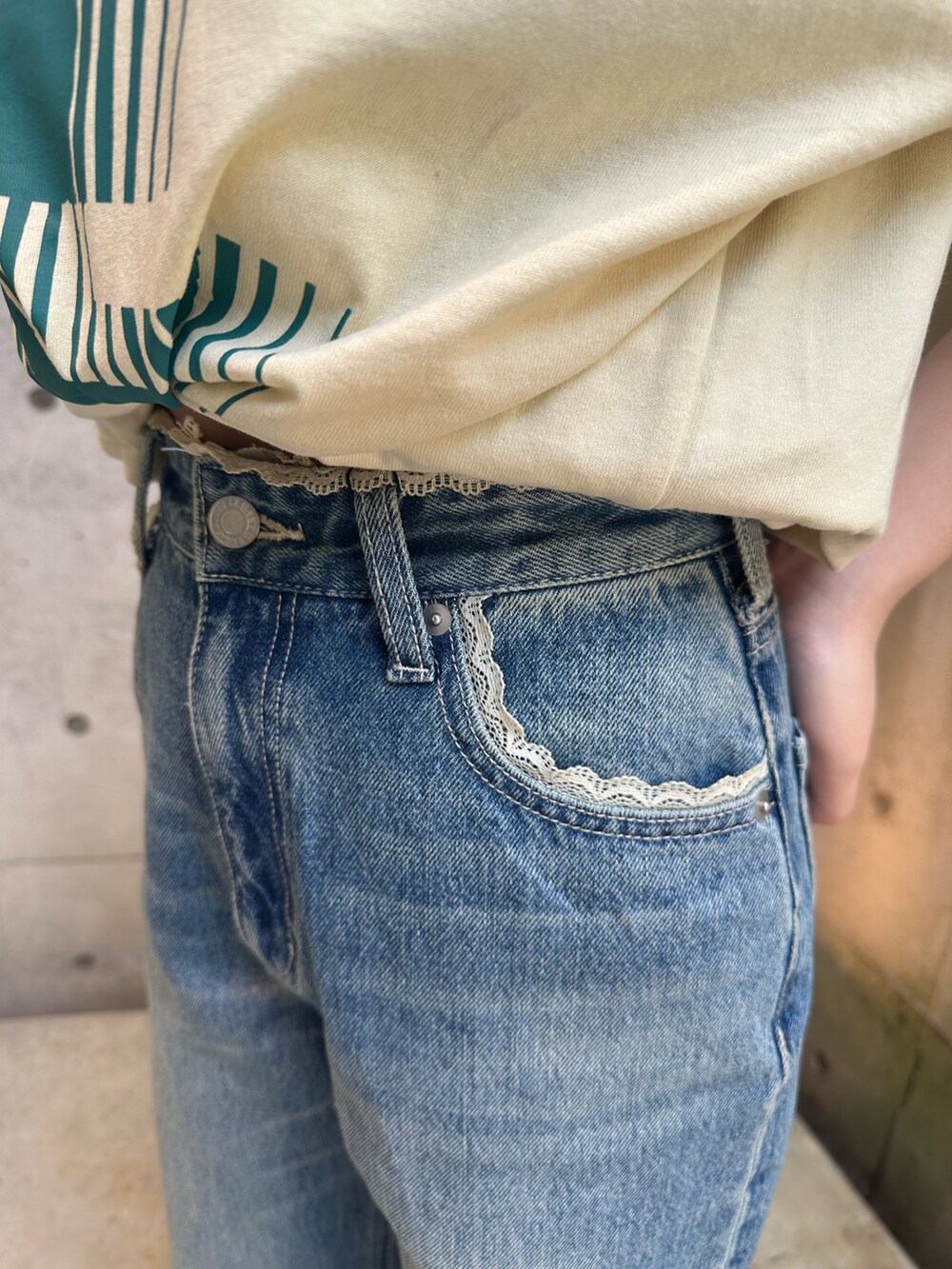 イエロー系のTシャツ/カットソー、ブルー系のデニムパンツ、ブラウン系のブーツを着用したレディースの春コーディネートの6枚目の写真