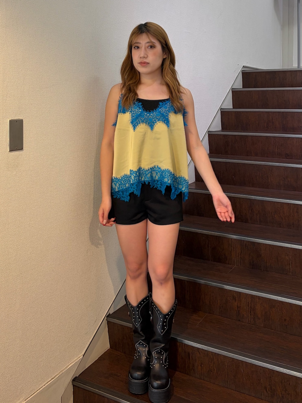 ブラック系のその他パンツ、ブラック系のブーツ、イエロー系のキャミソールを着用したレディースの春コーディネートの2枚目の写真