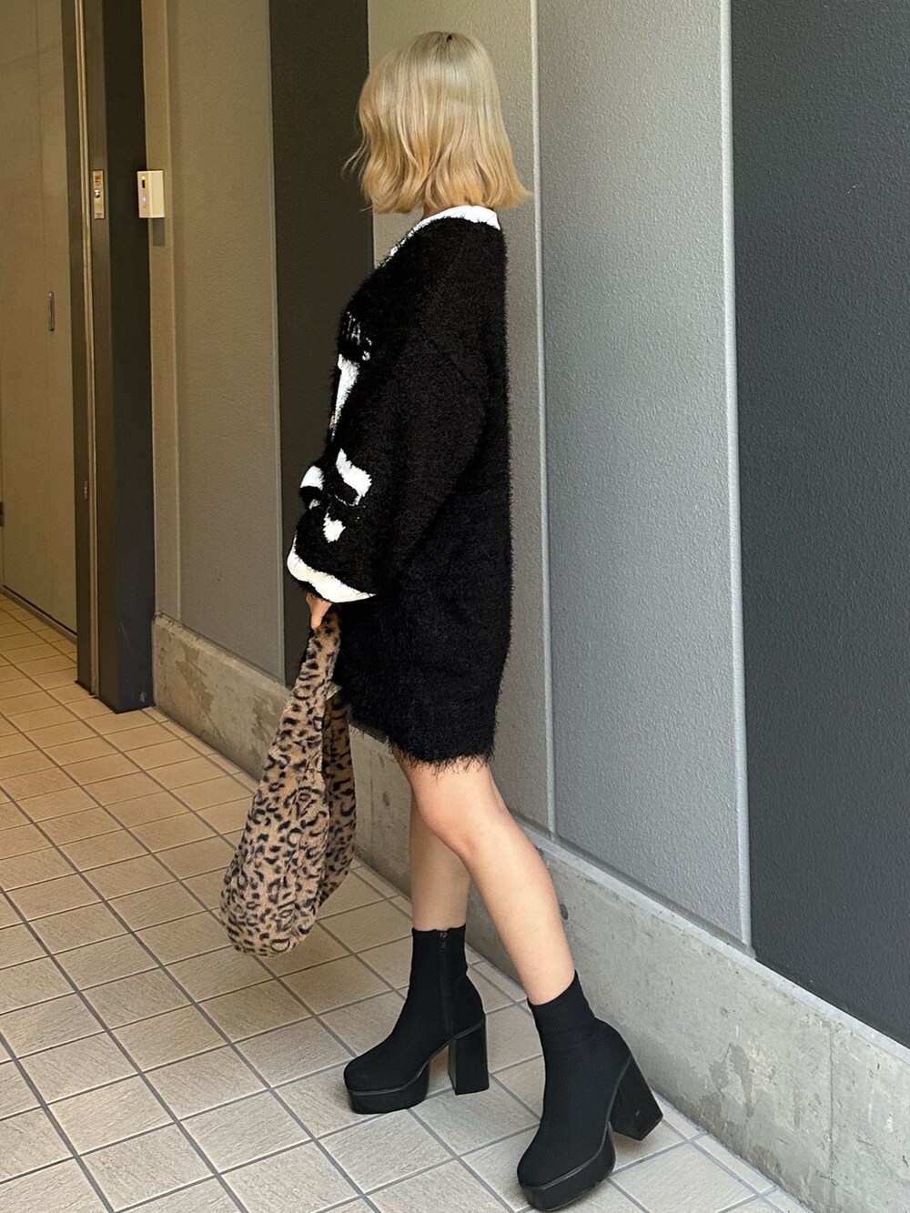 その他のブーツ、ブラック系のニット/セーター、その他のショルダーバッグを着用したレディースの秋コーディネートの2枚目の写真