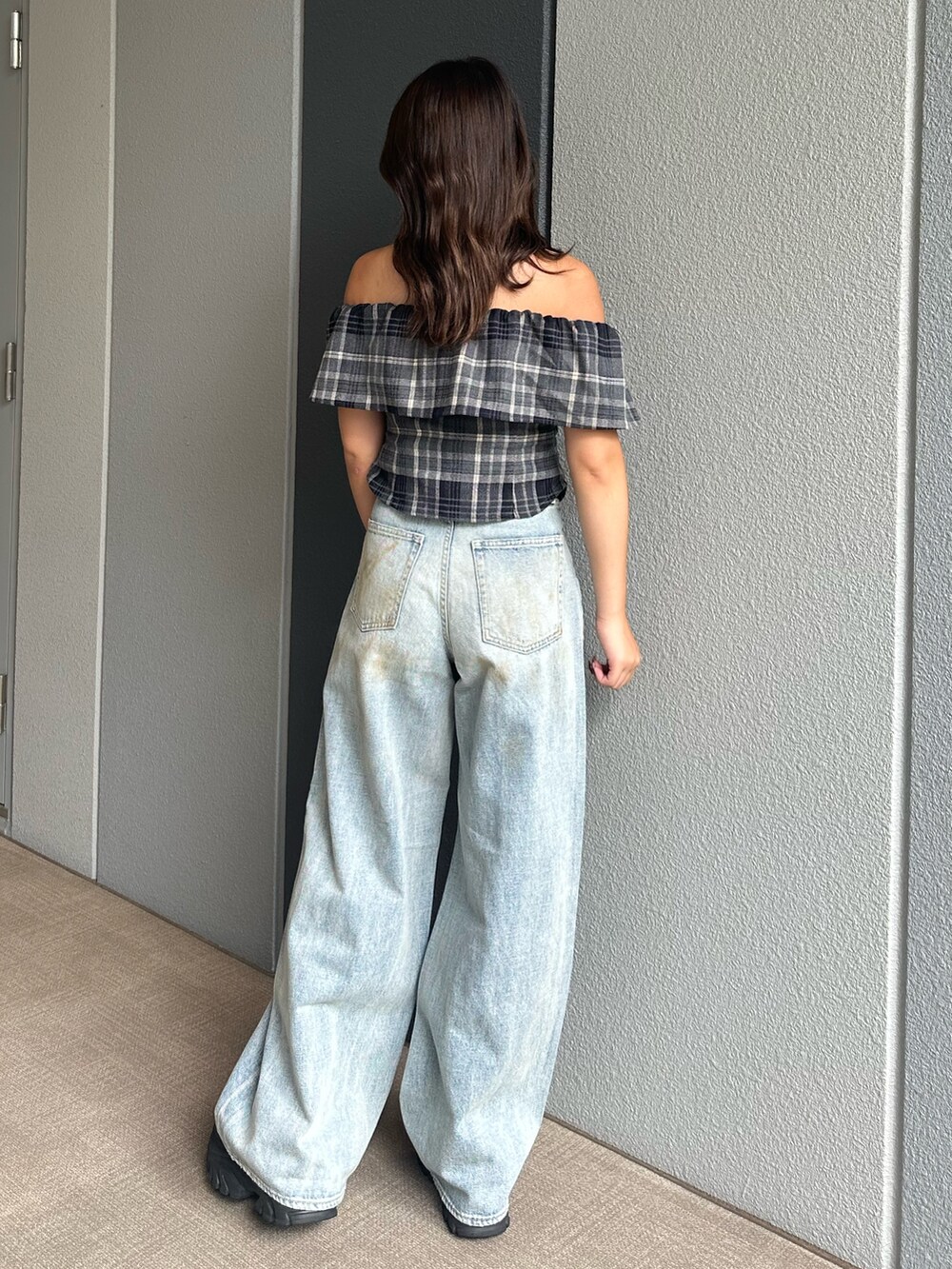 ブルー系のデニムパンツ、ブラック系のシャツ/ブラウス、ブラック系のサンダルを着用したレディースの夏コーディネートの3枚目の写真