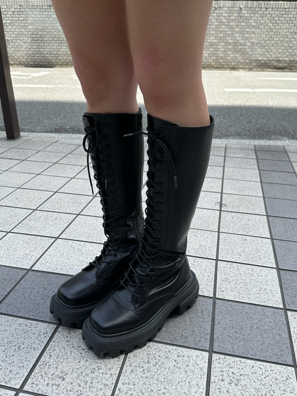 イエロー系のシャツ/ブラウス、ブラック系のブーツ、ホワイト系のショルダーバッグを着用したレディースの春コーディネートの7枚目の写真