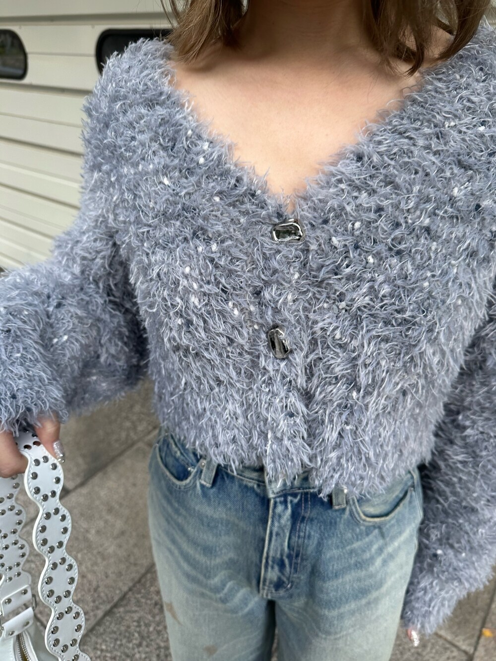 グレー系のカーディガン/ボレロ、ブルー系のデニムパンツを着用したレディースの冬コーディネートの7枚目の写真