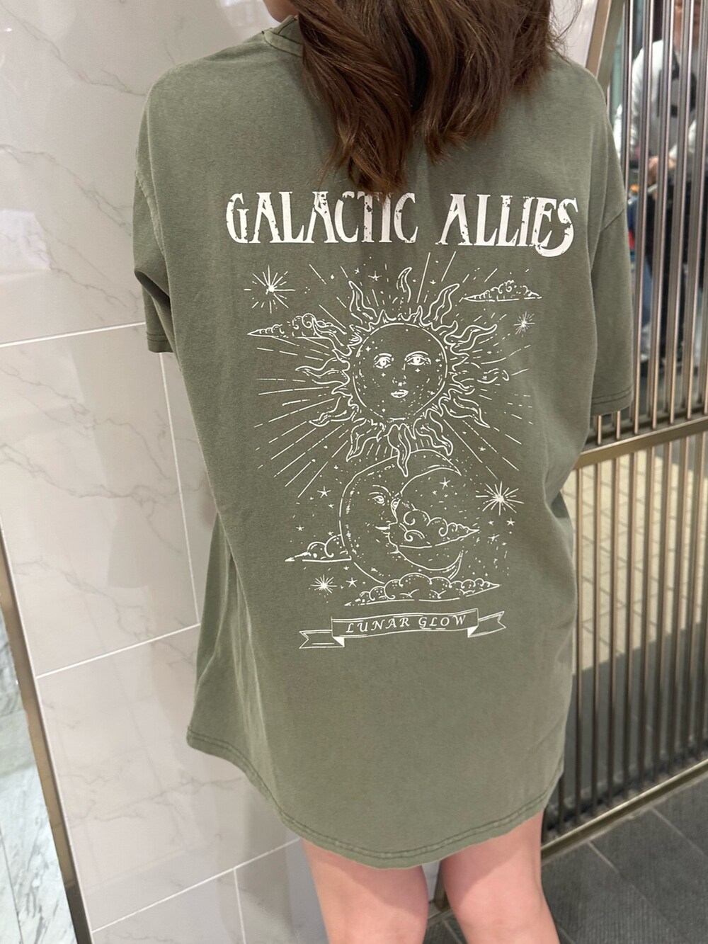 ブラック系のショルダーバッグ、ブラウン系のブーツ、グリーン系のTシャツ/カットソーを着用したレディースの春コーディネートの5枚目の写真