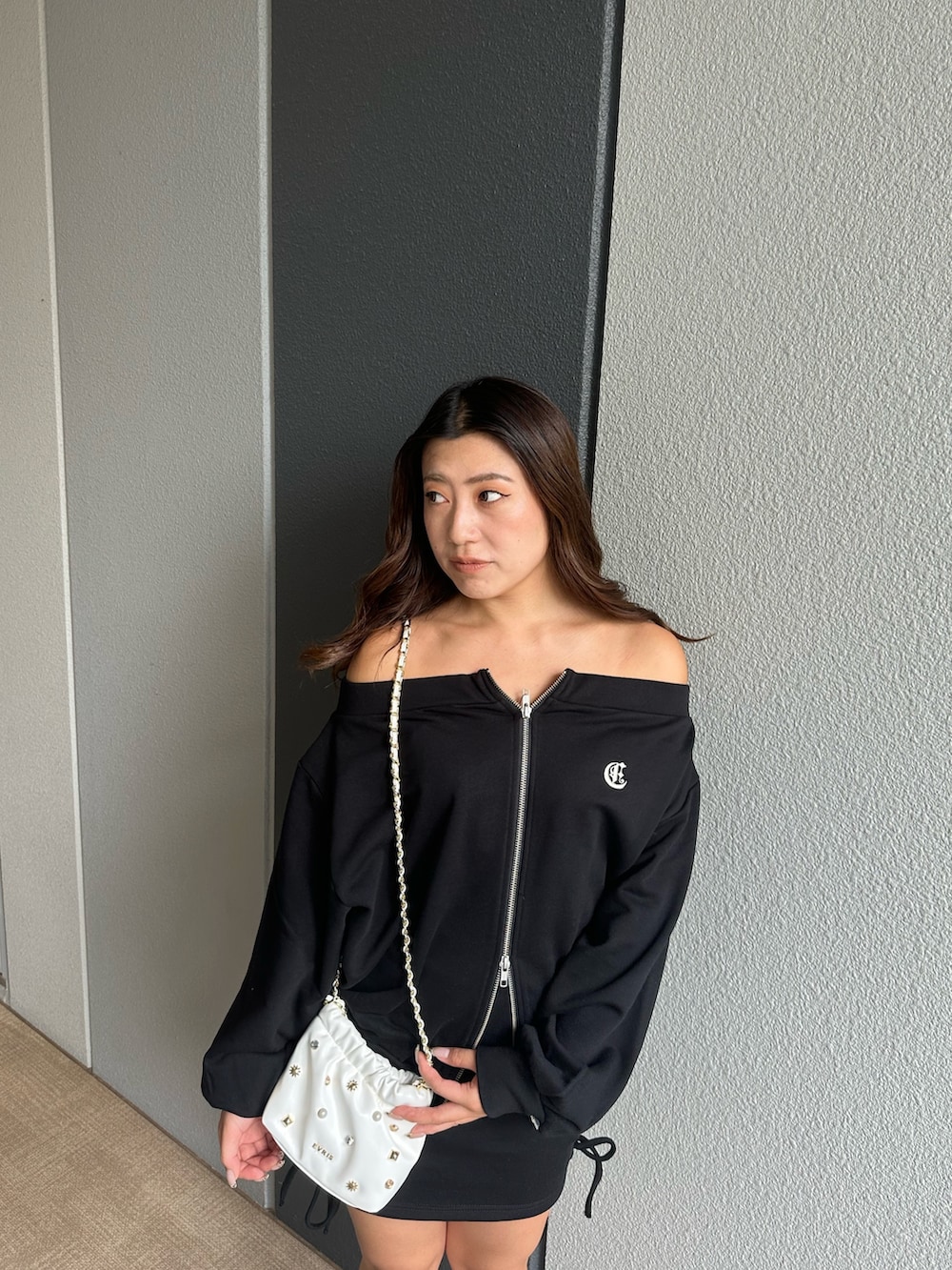 ブラック系のパーカー、ブラック系のスカート、ブラック系のブーツを着用したレディースの秋コーディネートの4枚目の写真