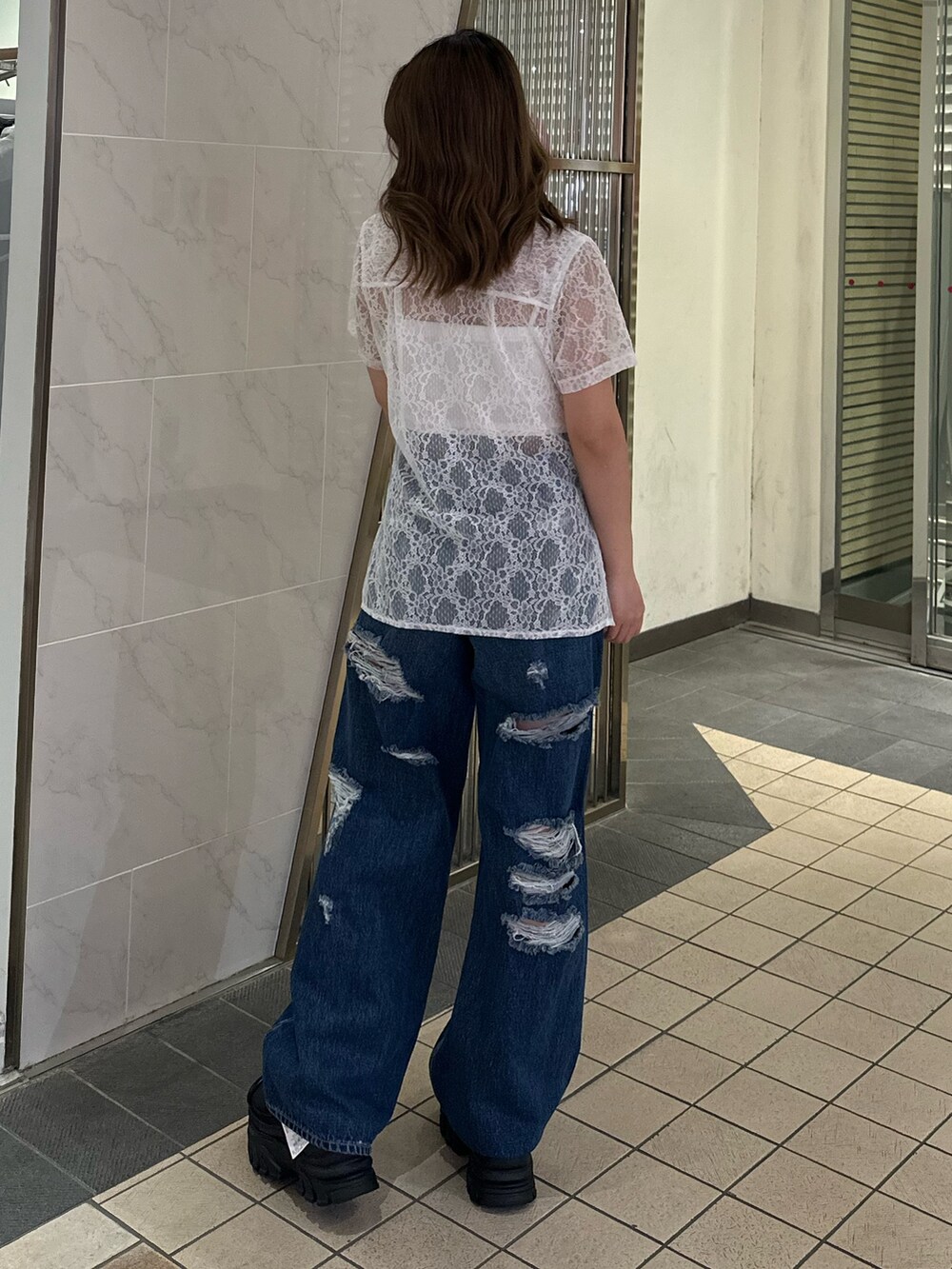 ホワイト系のシャツ/ブラウス、ブルー系のデニムパンツ、ブラック系のサンダルを着用したレディースの春コーディネートの3枚目の写真