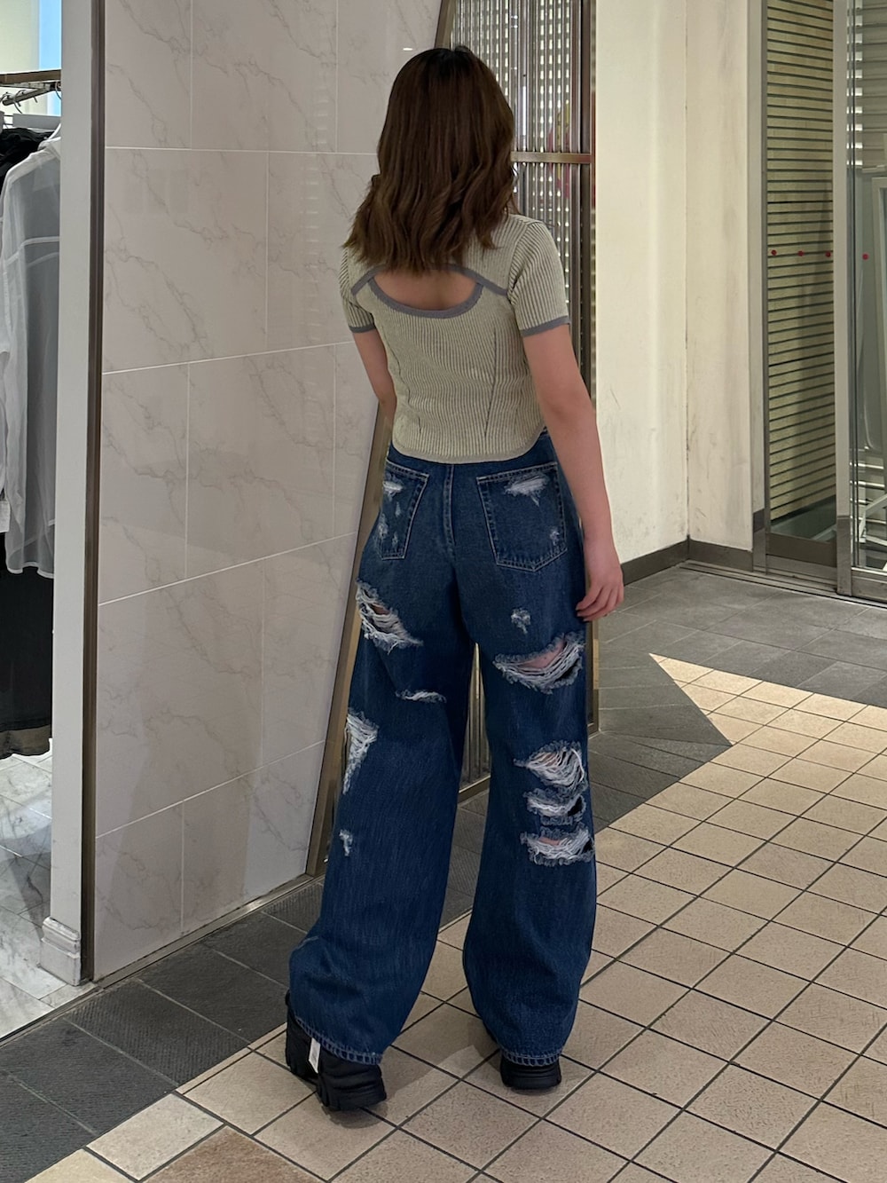 ブルー系のデニムパンツ、ブラック系のサンダル、イエロー系のニット/セーターを着用したレディースの春コーディネートの3枚目の写真