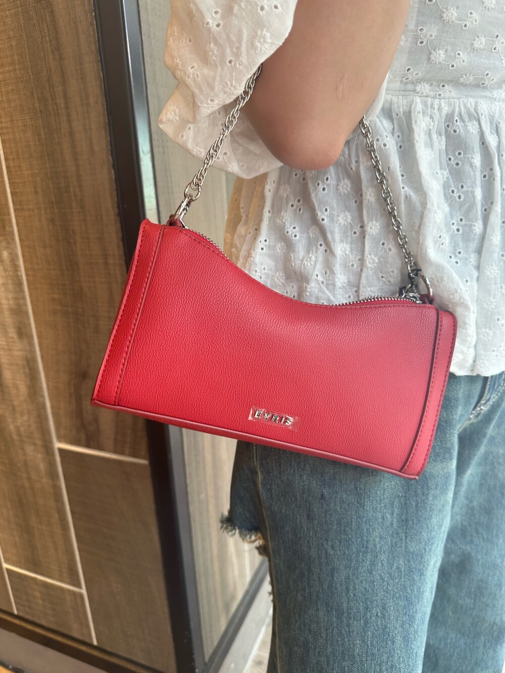 ブルー系のデニムパンツ、ホワイト系のシャツ/ブラウス、レッド系のショルダーバッグを着用したレディースの夏コーディネートの8枚目の写真