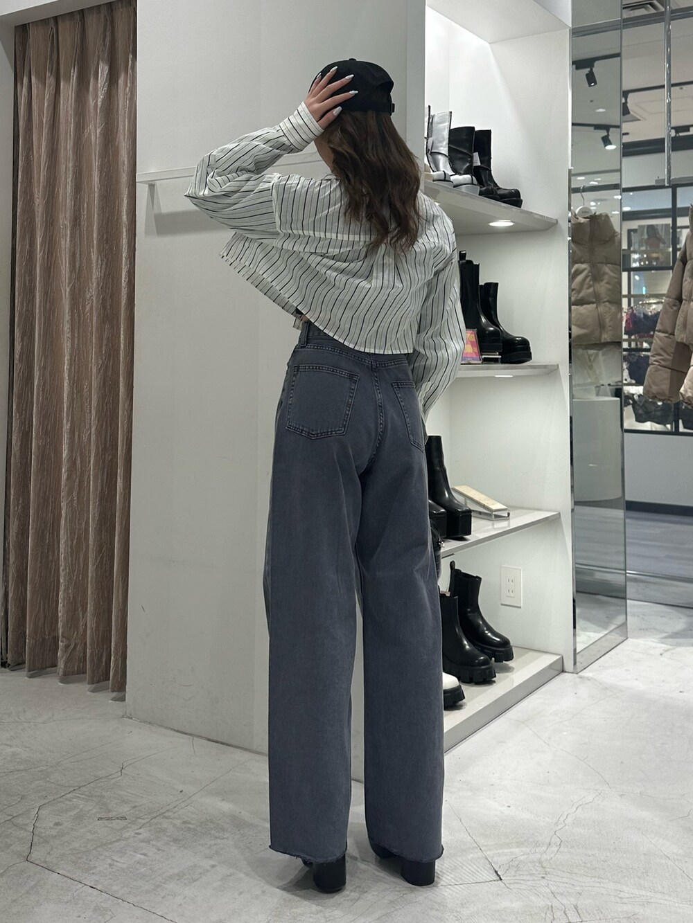 グレー系のデニムパンツ、ホワイト系のシャツ/ブラウス、ブラック系のショルダーバッグを着用したレディースの冬コーディネートの3枚目の写真