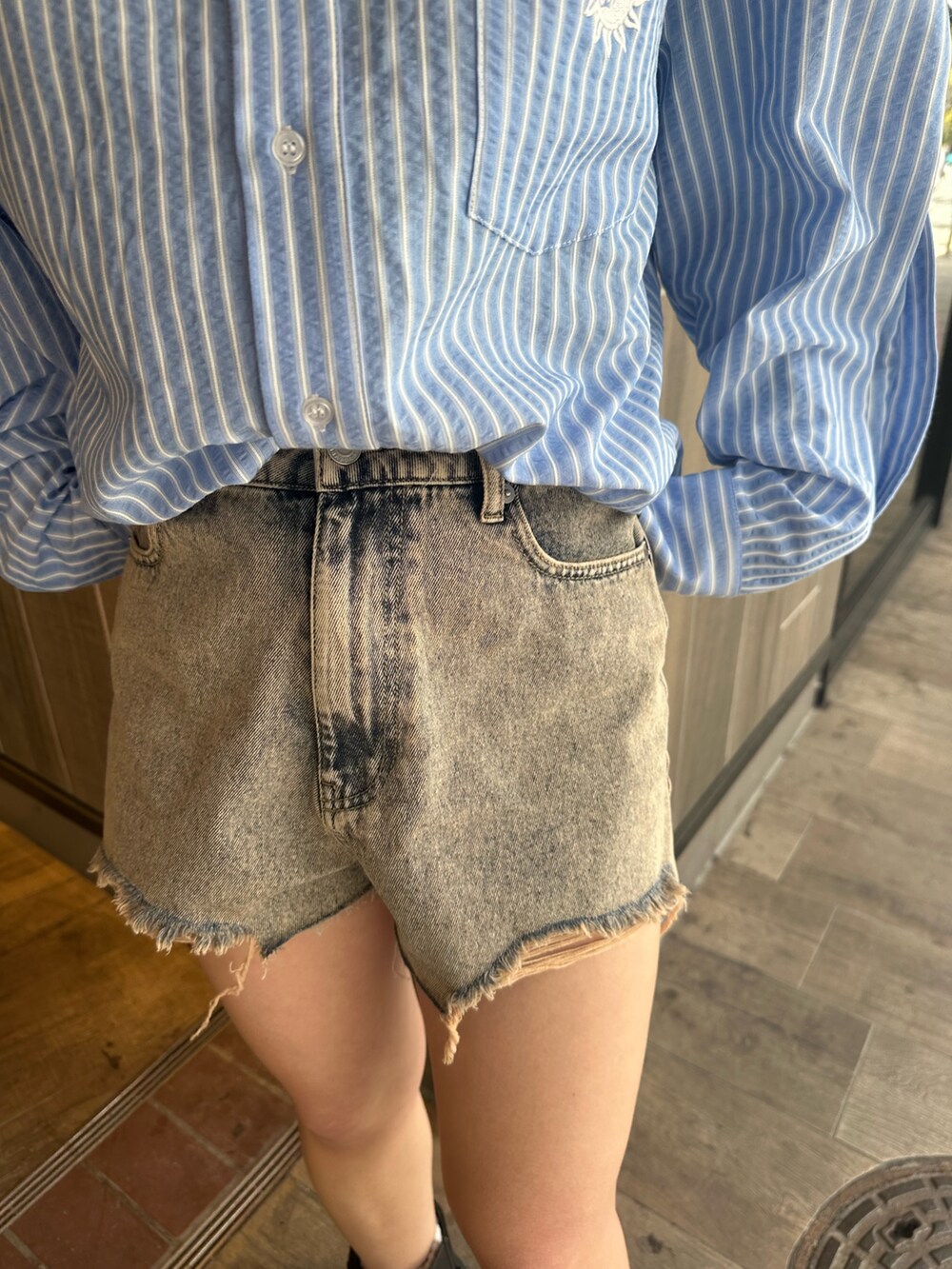 ブルー系のシャツ/ブラウス、ブラック系のブーツ、ベージュ系のデニムパンツを着用したレディースの春コーディネートの7枚目の写真