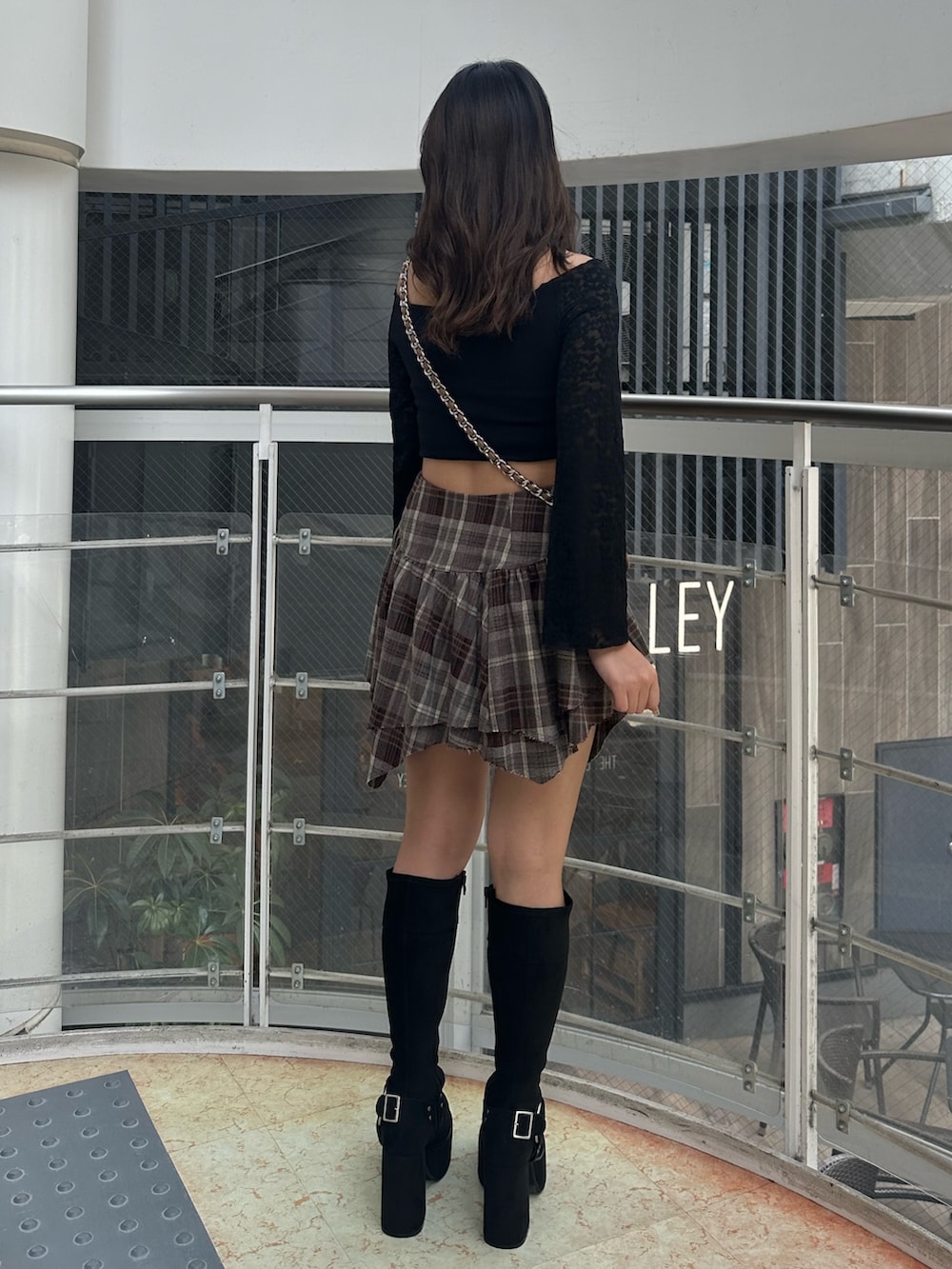 ベージュ系のハンドバッグ、ブラック系のTシャツ/カットソー、ブラック系のブーツを着用したレディースの秋コーディネートの3枚目の写真