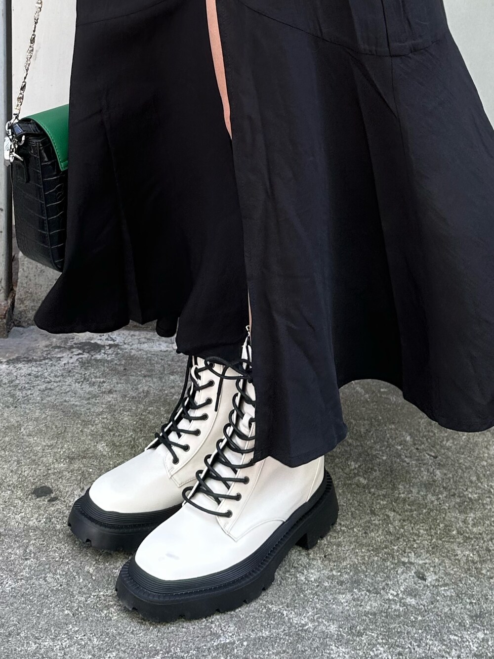 ブラック系のワンピース、ホワイト系のブーツ、ブラック系のショルダーバッグを着用したレディースの春コーディネートの8枚目の写真