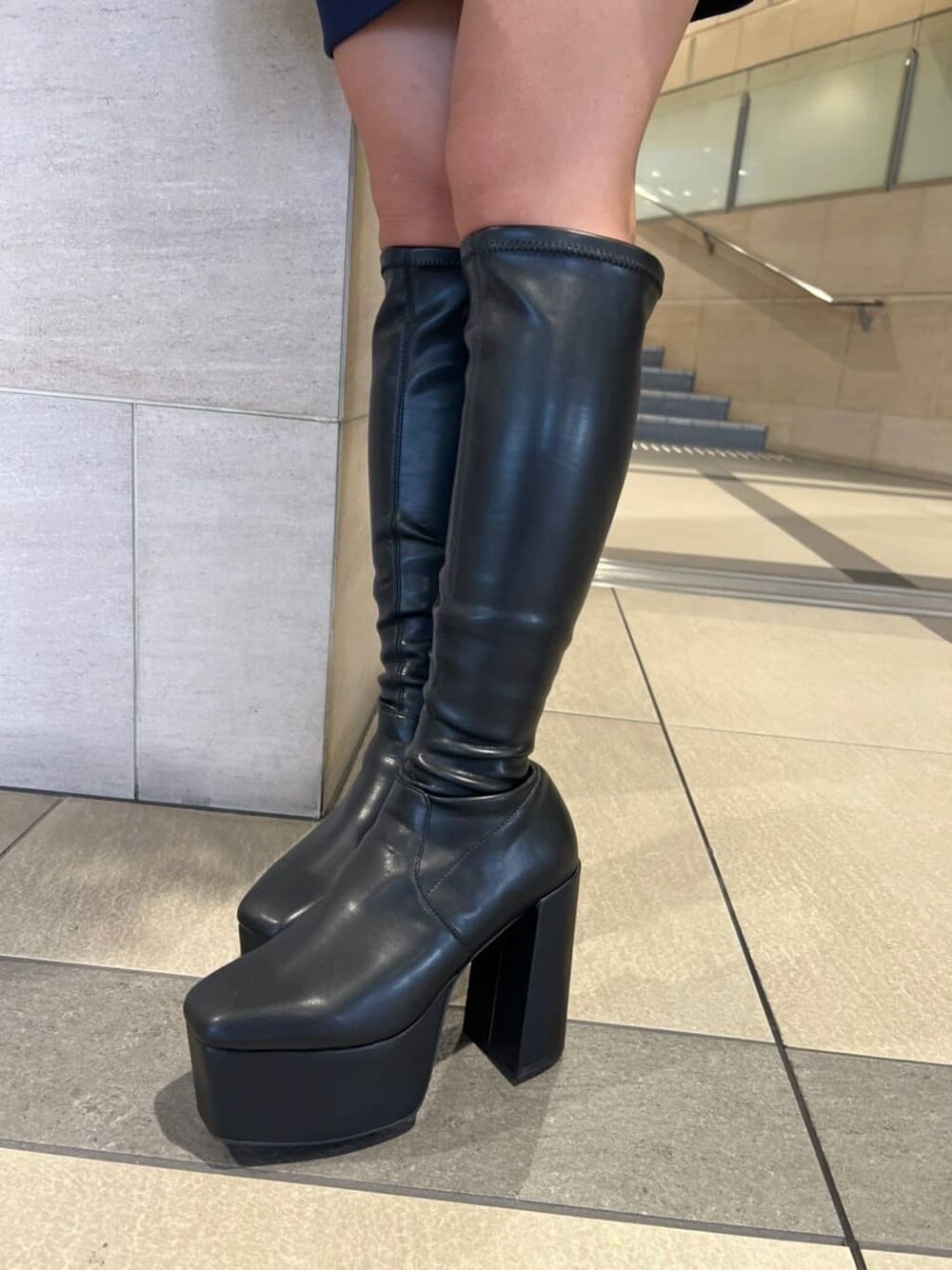 ブラック系のブーツ、ブラウン系のハンドバッグ、ブルー系のパーカーを着用したレディースの秋コーディネートの7枚目の写真