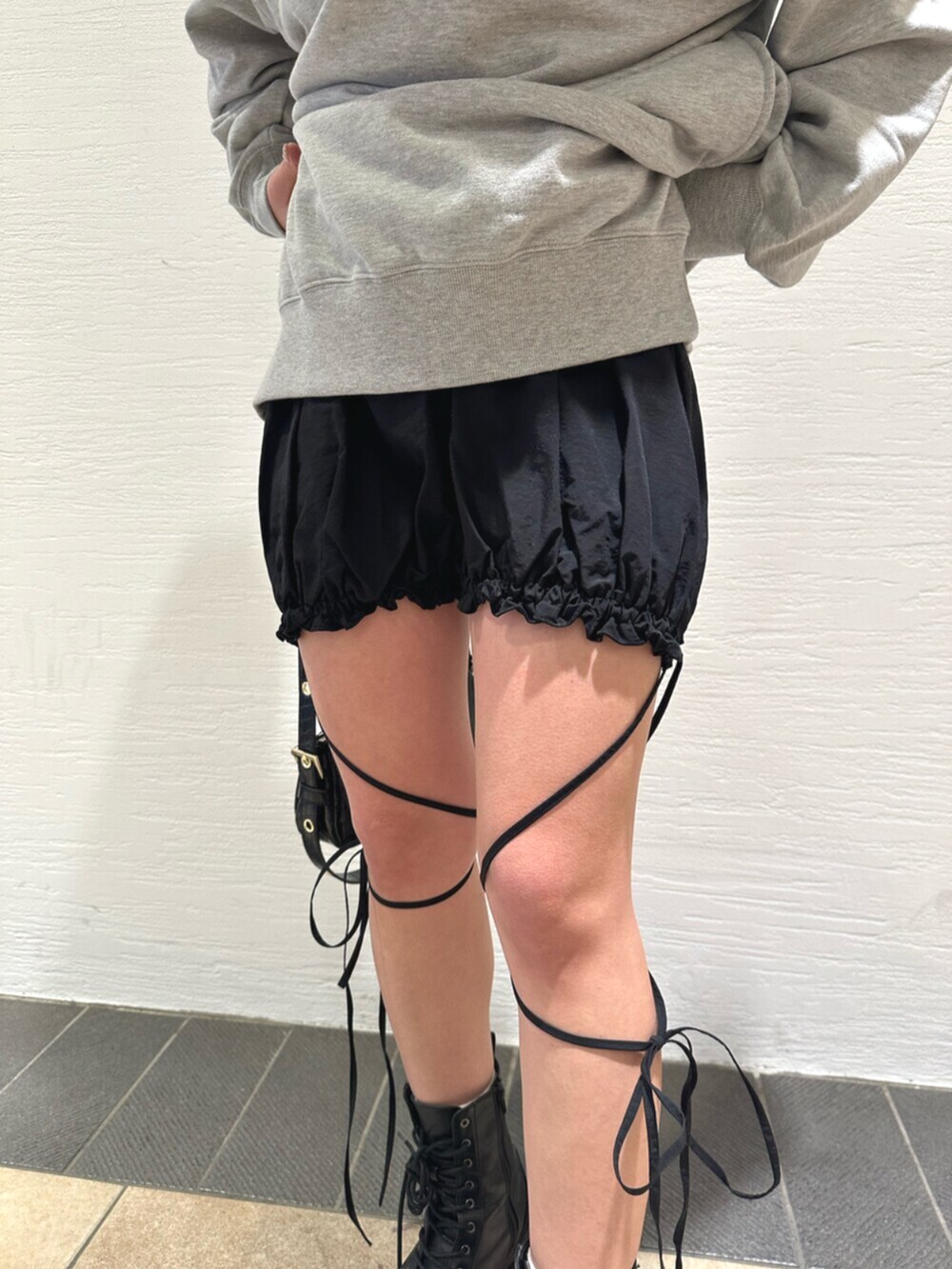 ブラック系のショルダーバッグ、ブラック系のブーツ、グレー系のスウェットを着用したレディースの冬コーディネートの9枚目の写真