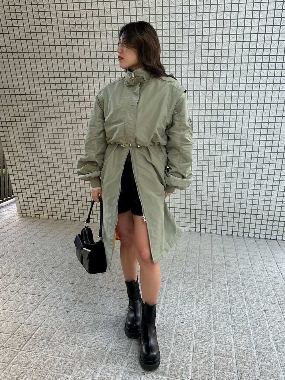 グレー系のニット/セーター、ブラック系のその他パンツ、ブラック系のブーツを着用したレディースの冬コーディネートの2枚目の写真