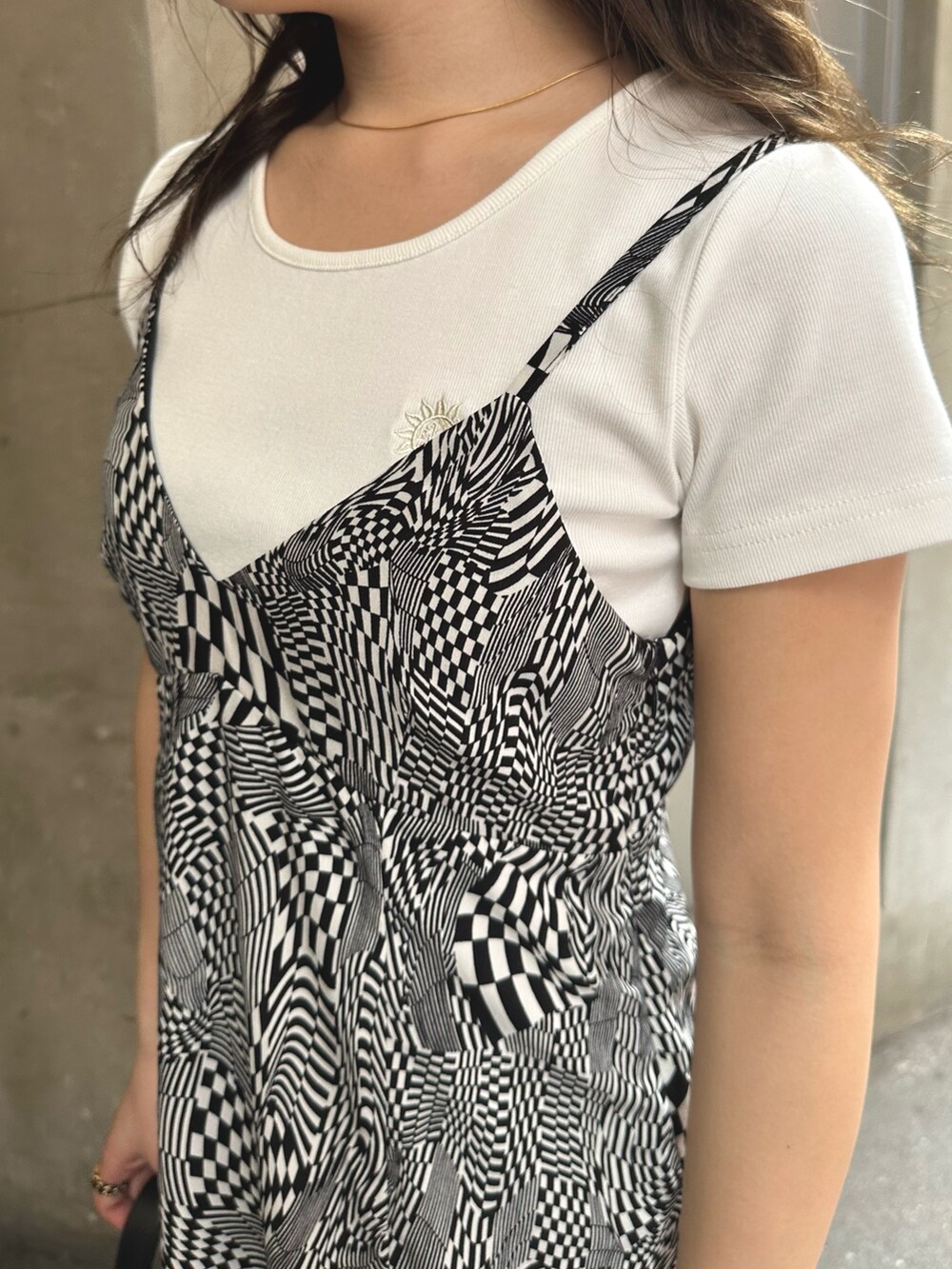 ブラック系のワンピース、ホワイト系のTシャツ/カットソー、ブラック系のハンドバッグを着用したレディースの春コーディネートの5枚目の写真