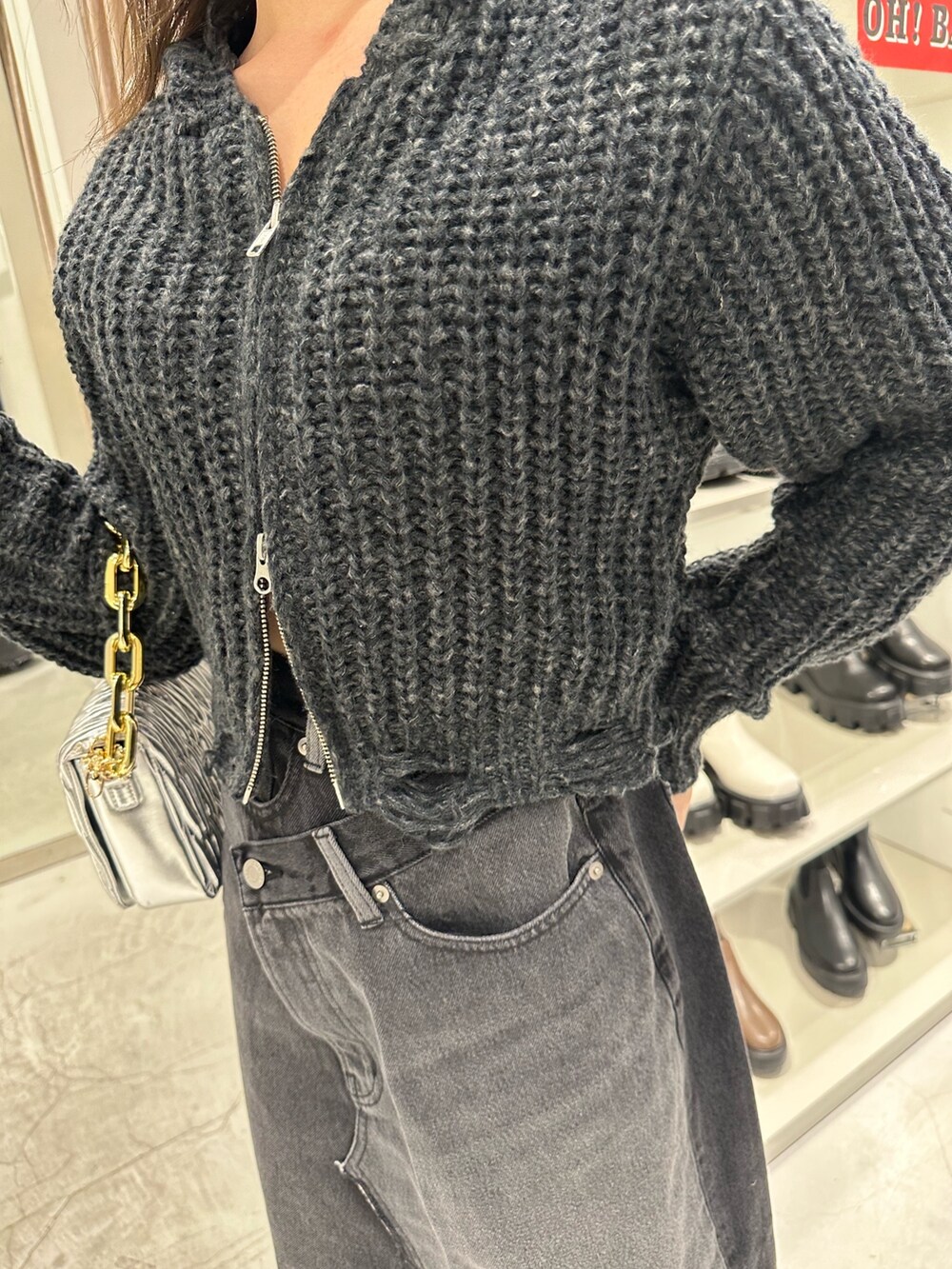 ブラック系のデニムスカート、ブラック系のニット/セーター、ブラック系のブーツを着用したレディースの冬コーディネートの6枚目の写真