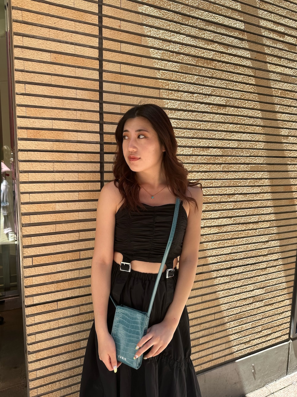 ブラック系のサンダル、ブルー系のショルダーバッグ、ブラック系のワンピースを着用したレディースの夏コーディネートの4枚目の写真